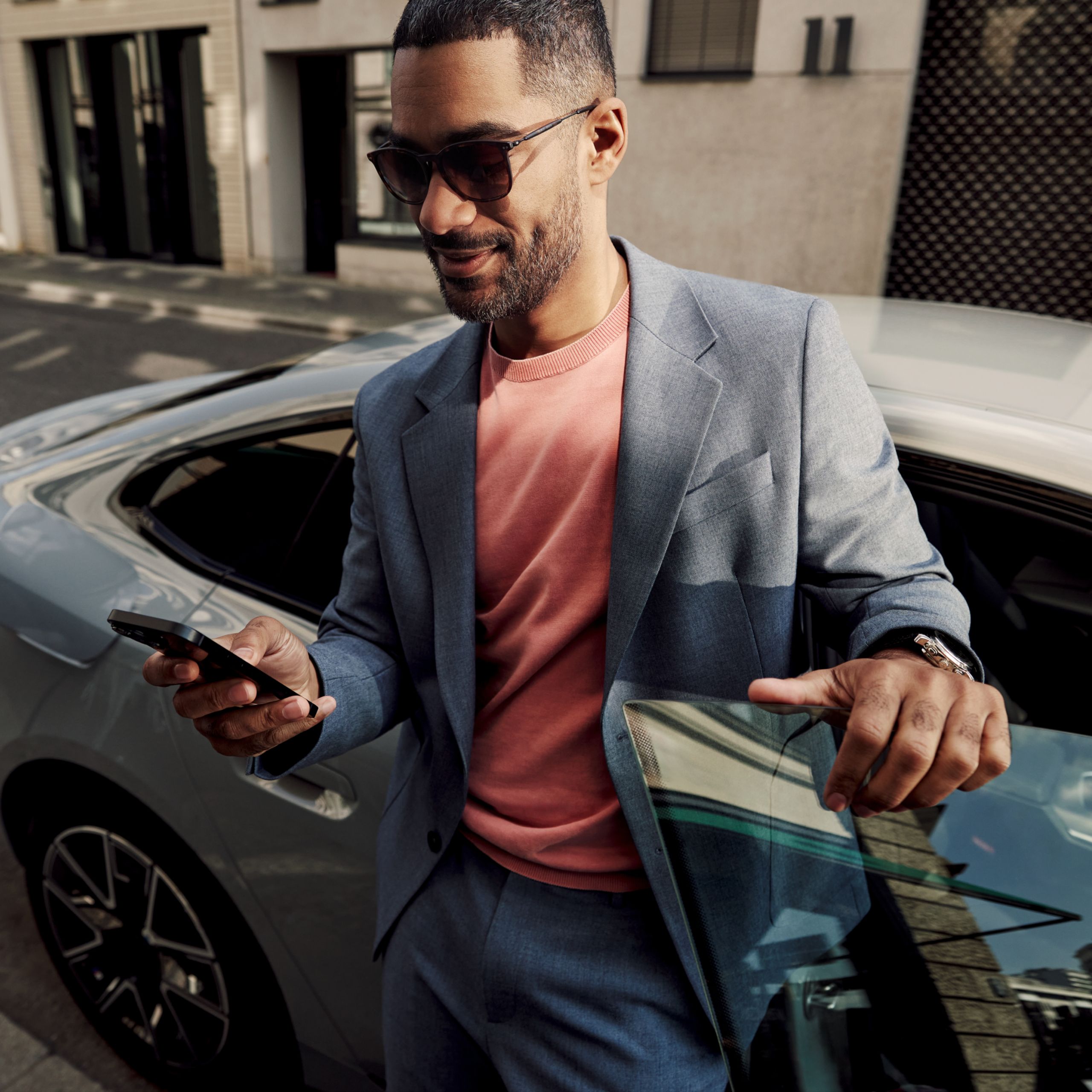 Passenger gets out of a vehicle and looks at his smartphone