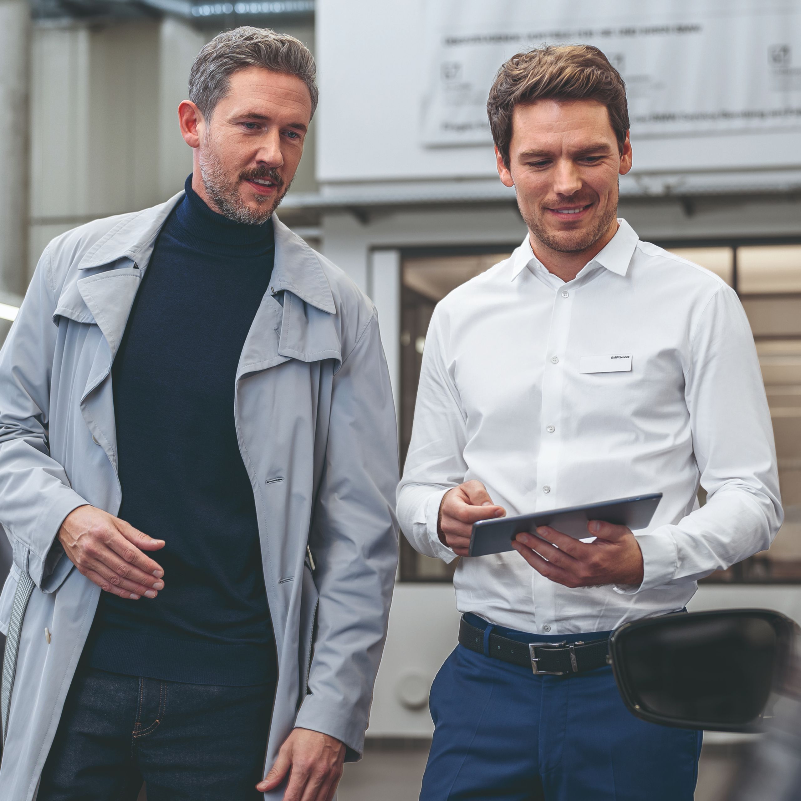 One person shows something to another person on a tablet