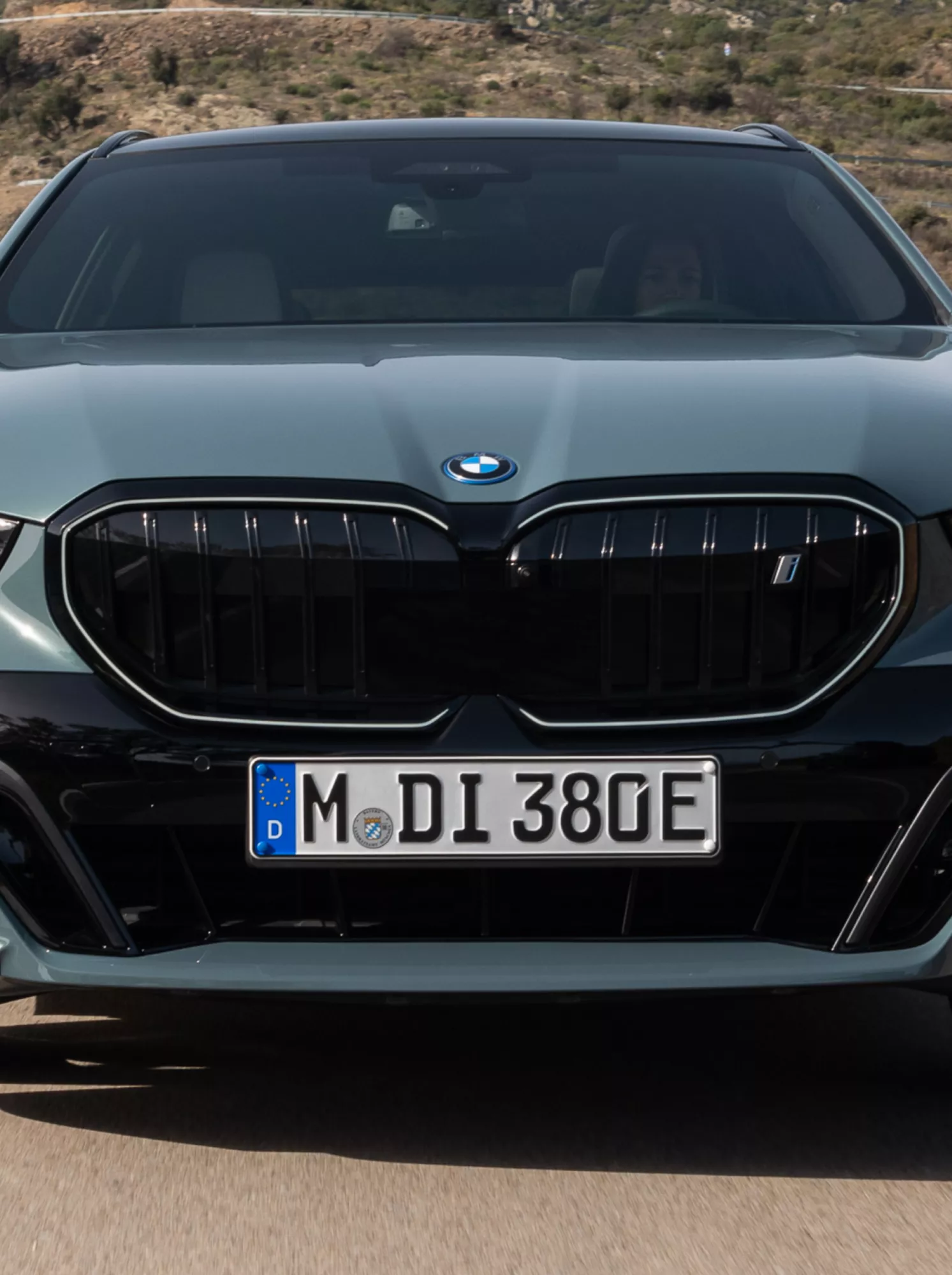A fully electric BMW is driving on a mountain road