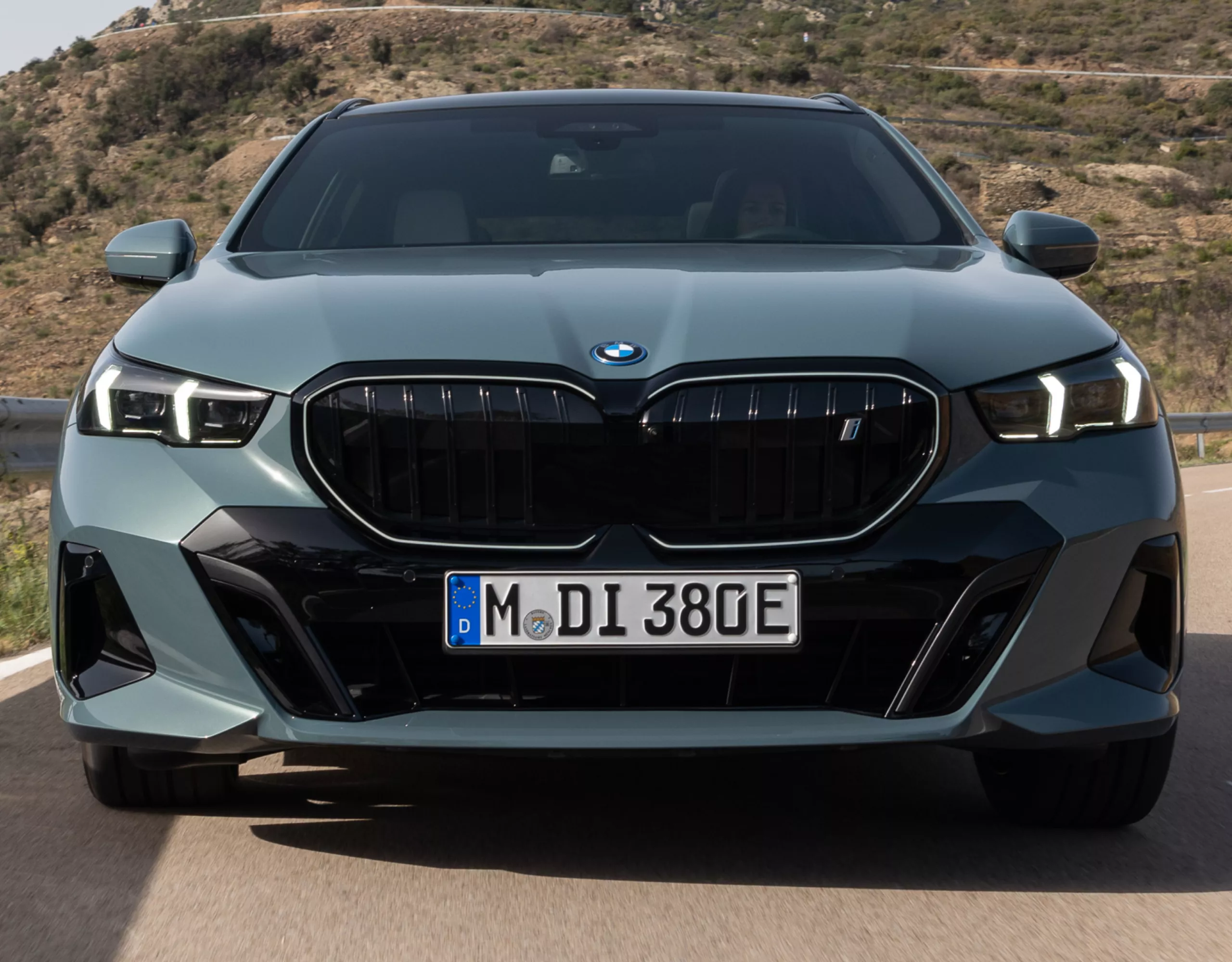 A fully electric BMW is driving on a mountain road