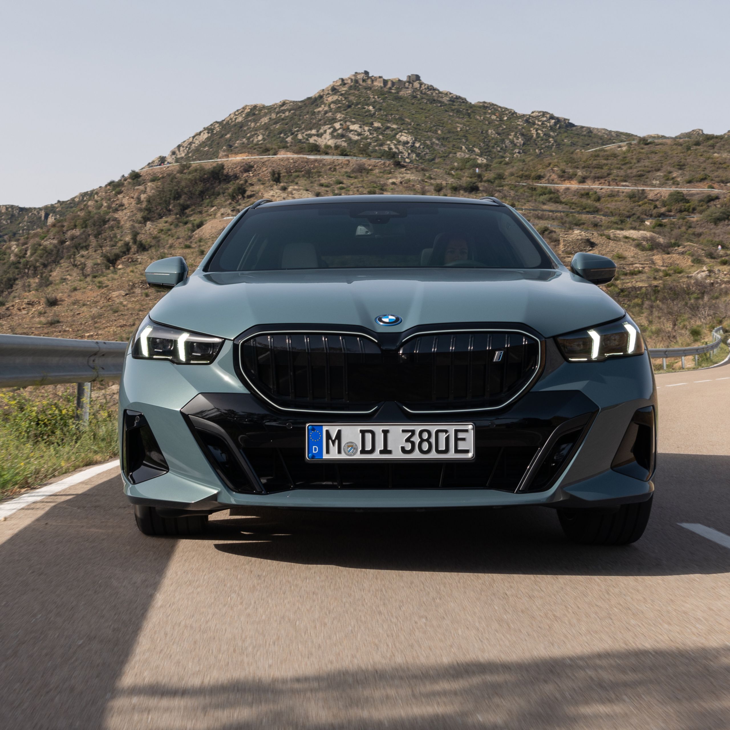 A fully electric BMW is driving on a mountain road
