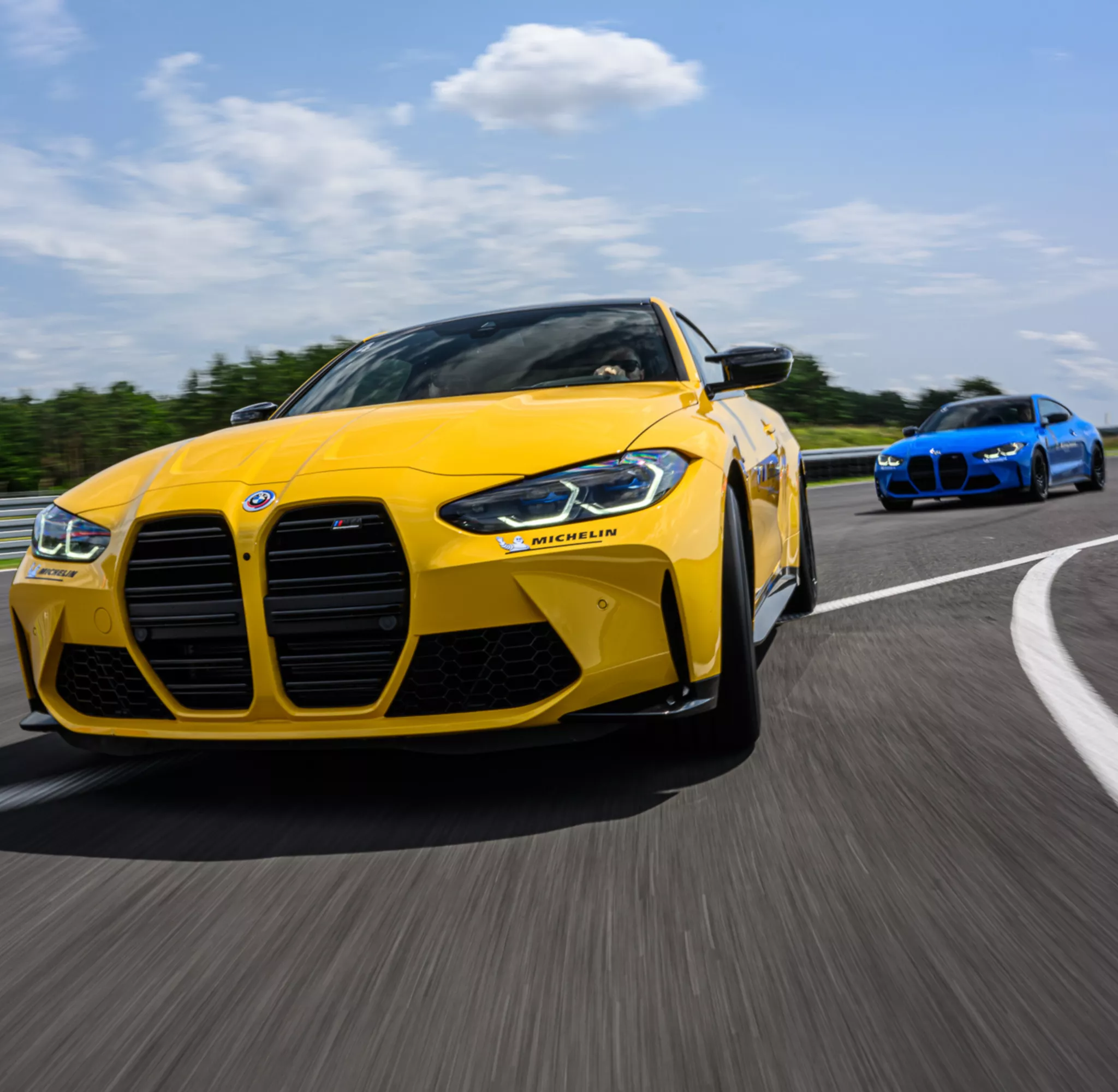 Samochody BMW jadące na torze Silesia Ring podczas Driving Experience, na prowadzeniu żółte BMW.