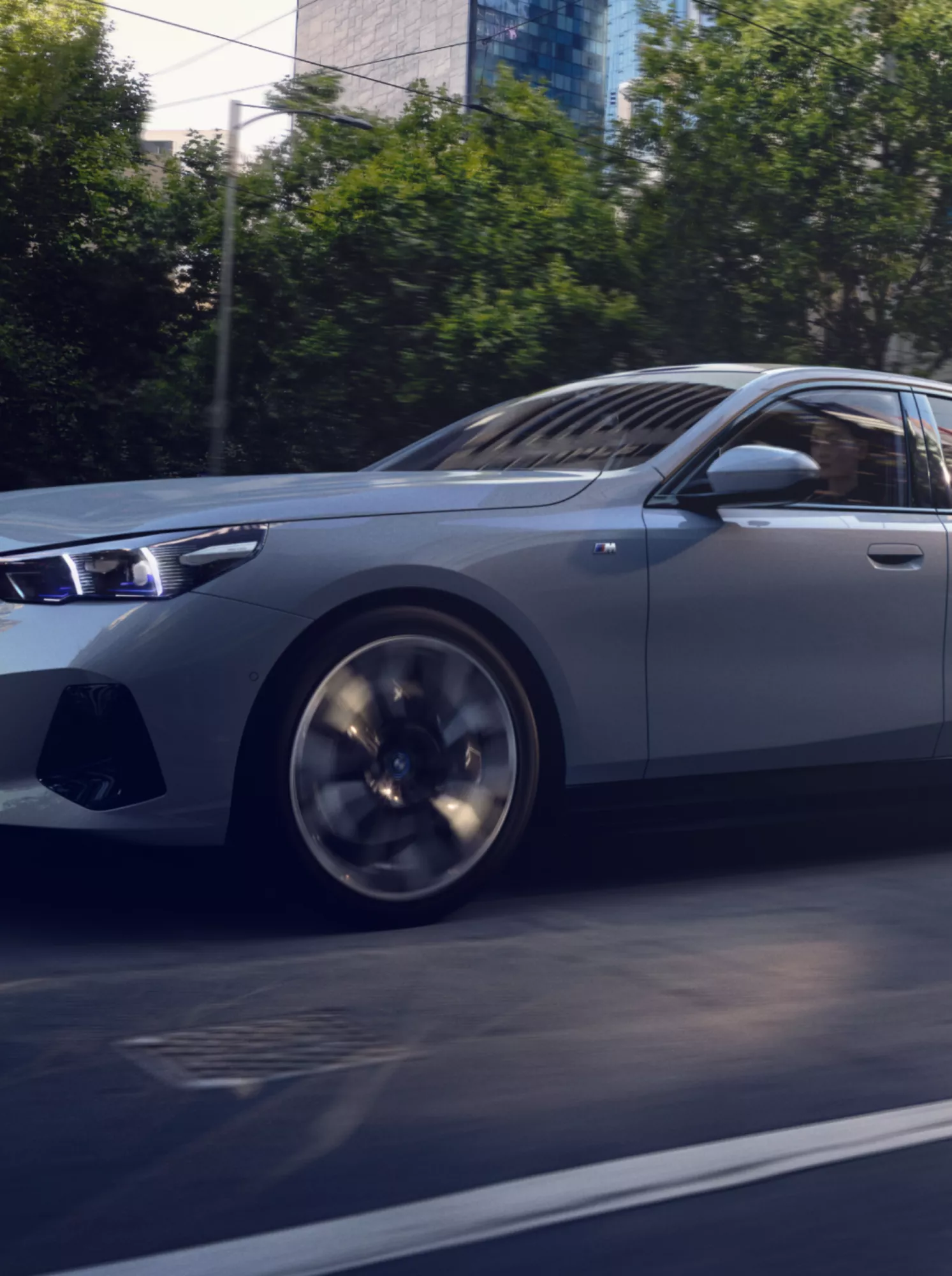 Zijaanzicht van een grijze BMW in een stadsstraat