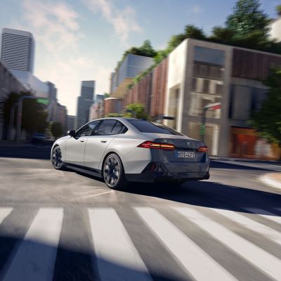 Rear view of a grey BMW i5 on a city road