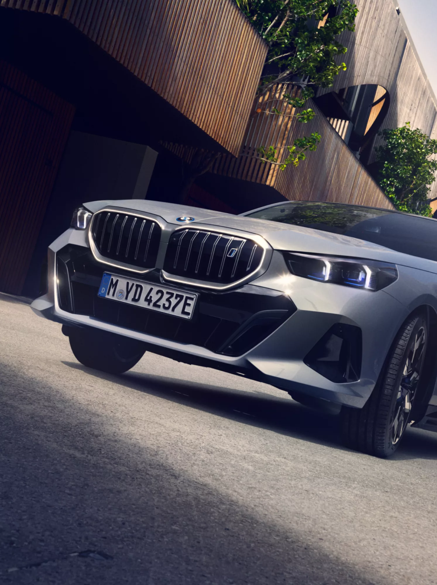 Ein BMW Elektrofahrzeug fährt durch eine begrünte Straße