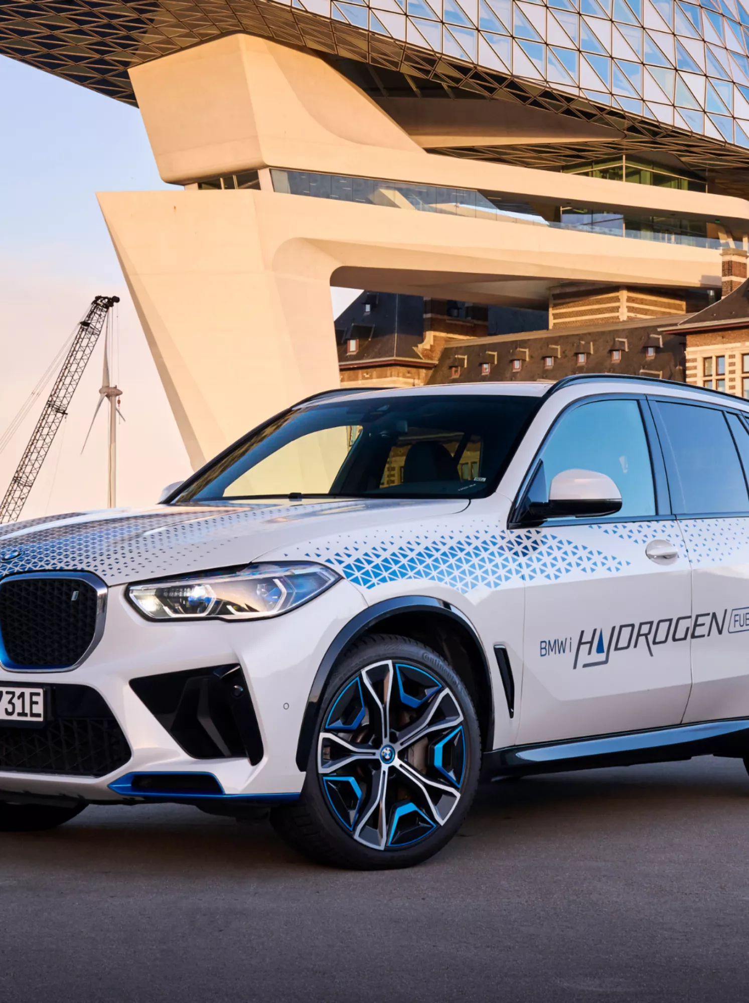 BMW iX5 Hydrogen vor einem Hafenvista im Sonnenuntergang