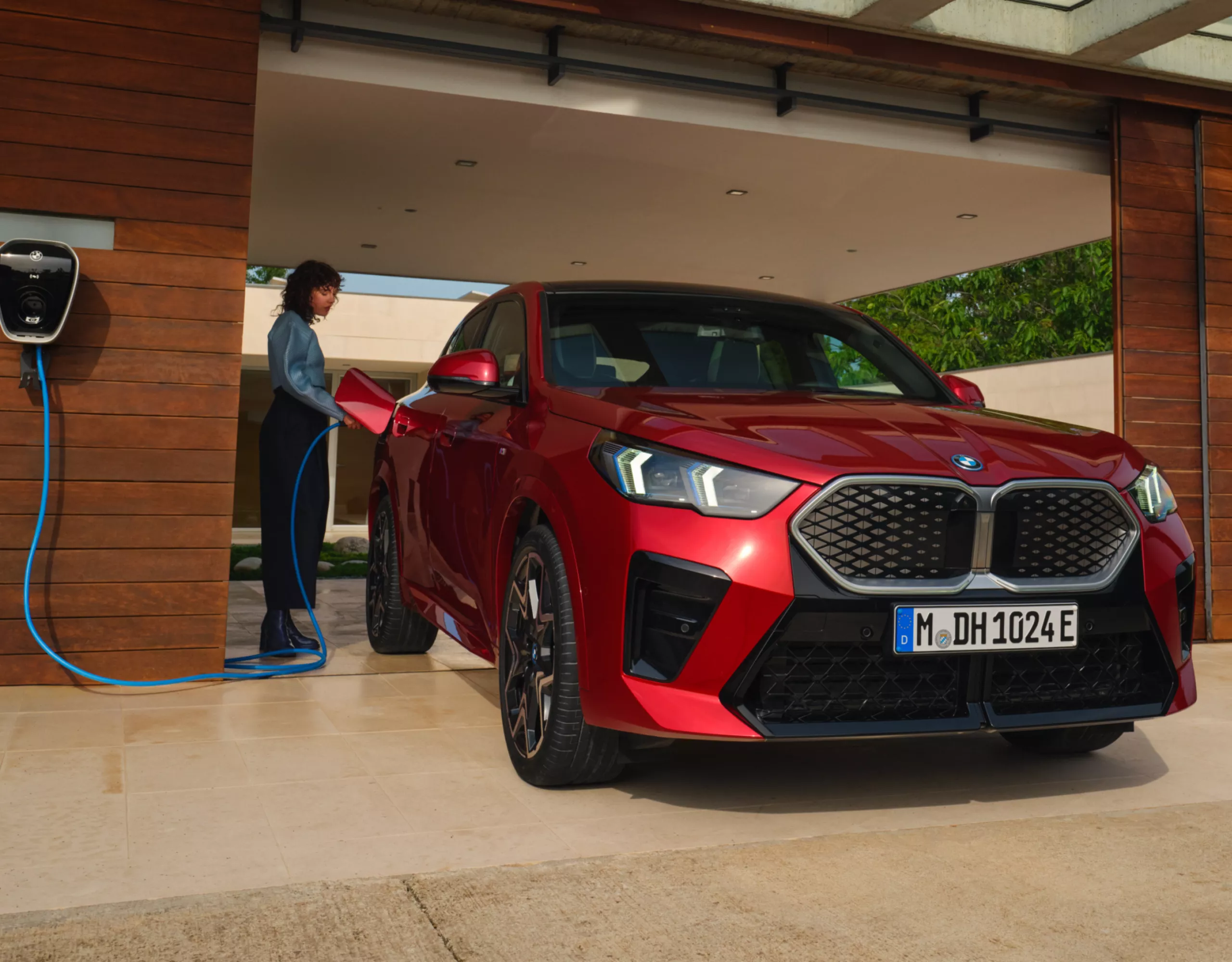 Ein rotes BMW Elektrofahrzeug lädt an einer Wallbox