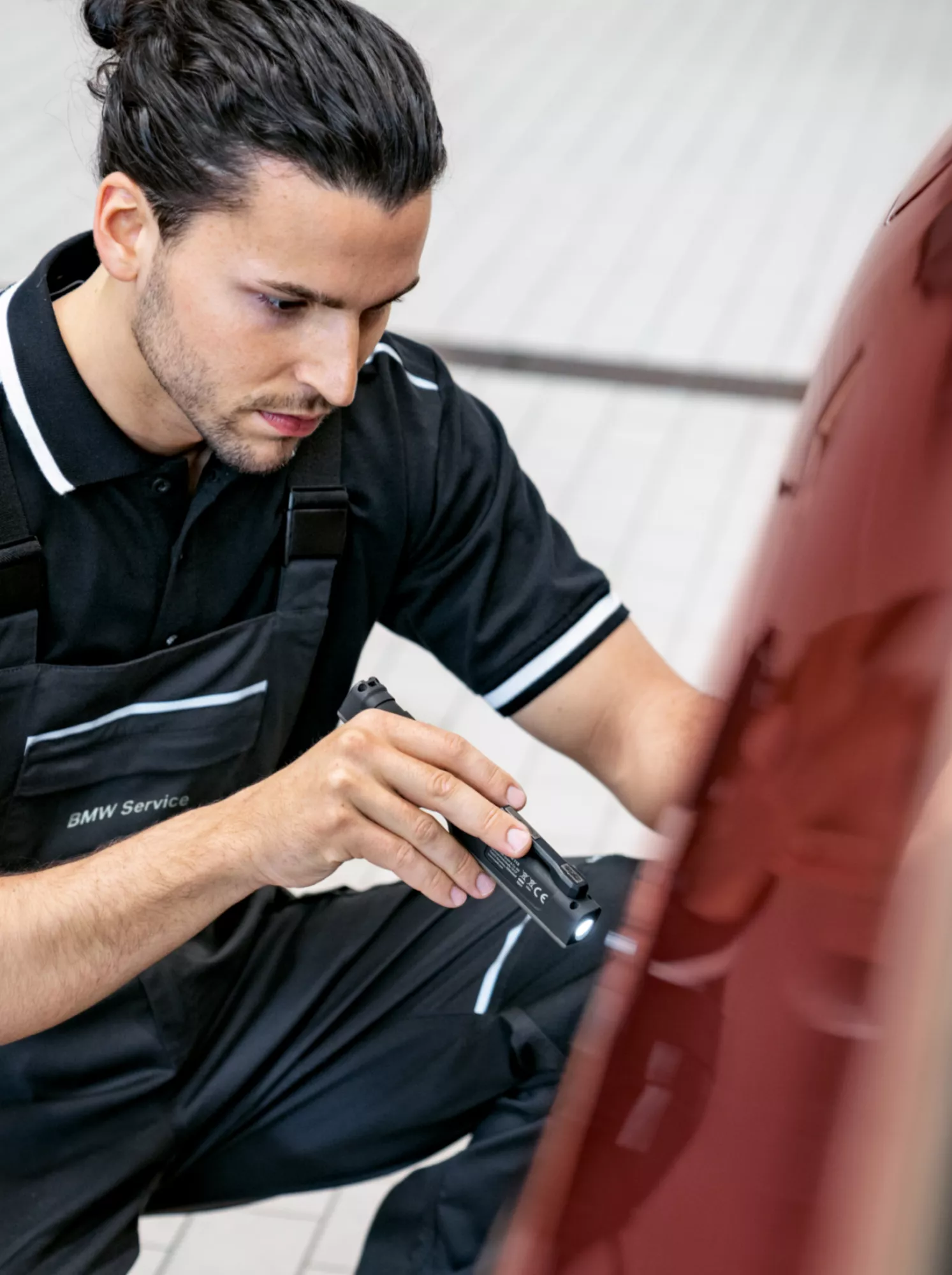 An employee of a BMW workshop is servicing a fully electric BMW