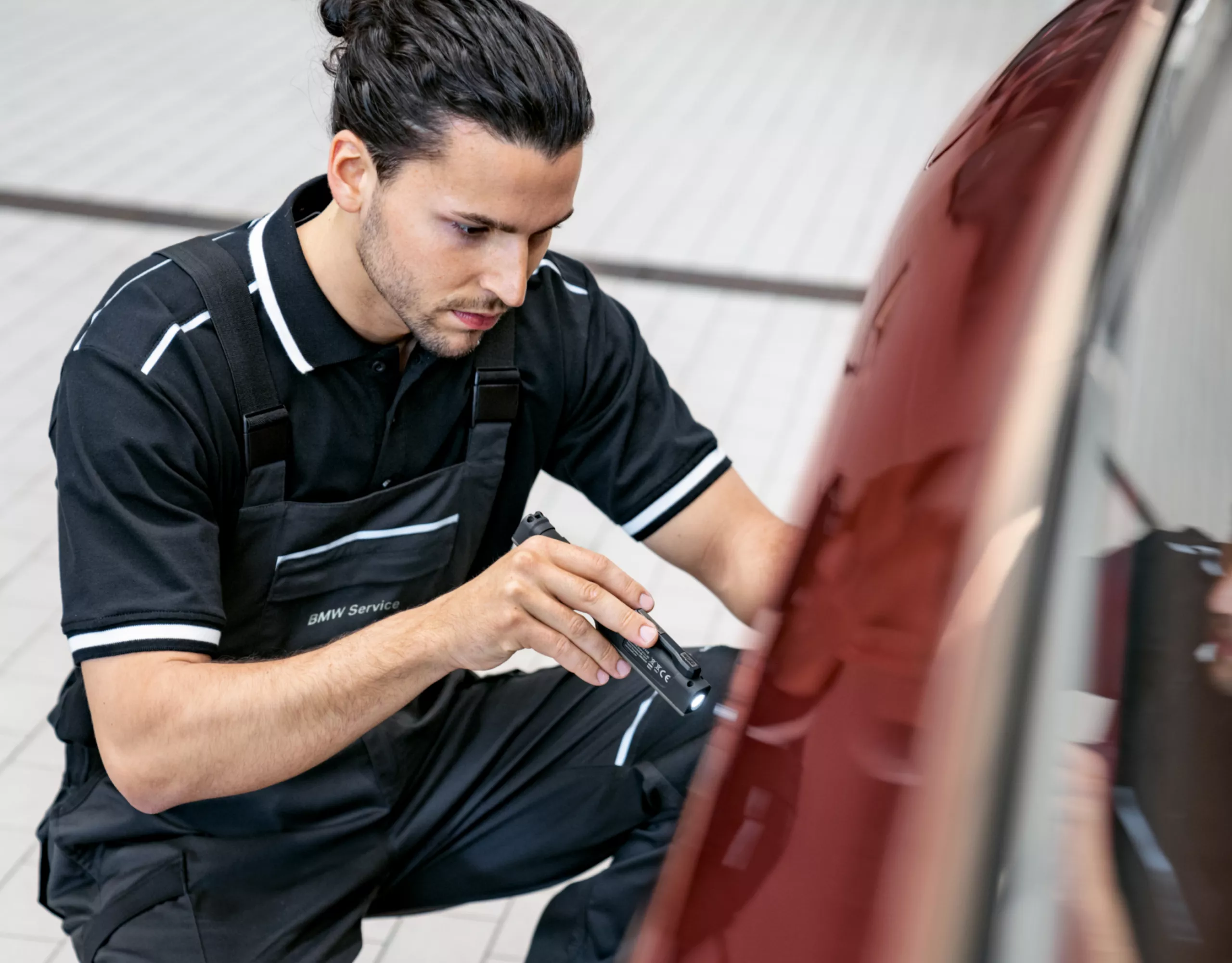 Ein Mitarbeiter einer BMW Werkstatt prüft ein Elektrofahrzeug