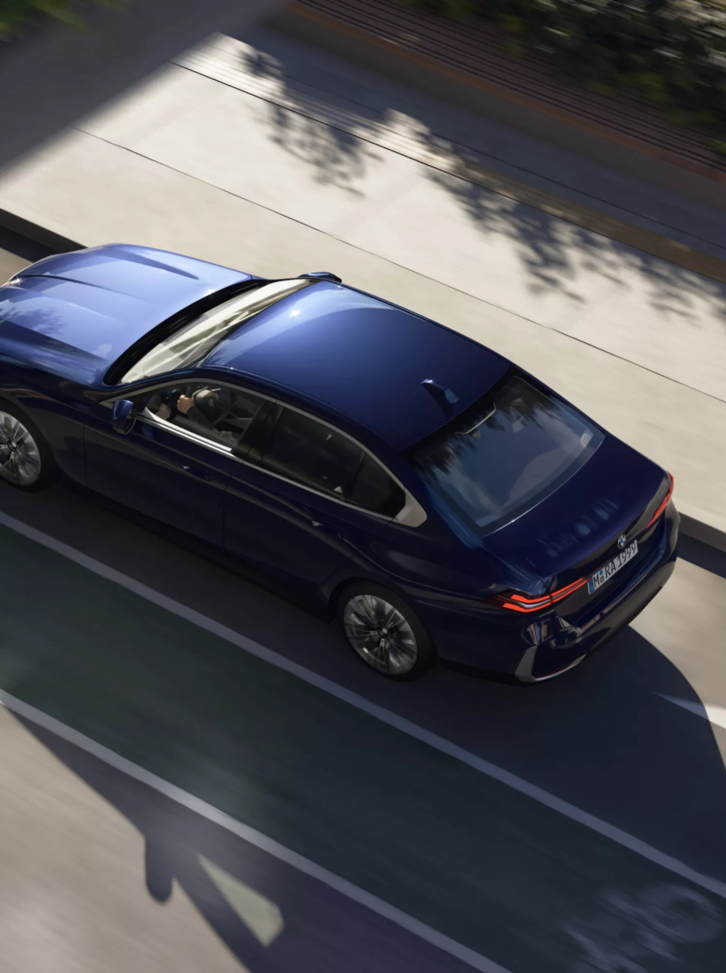 Eine BMW Limousine fährt innerorts auf einer Straße. Die Aufnahme zeigt das Auto von oben