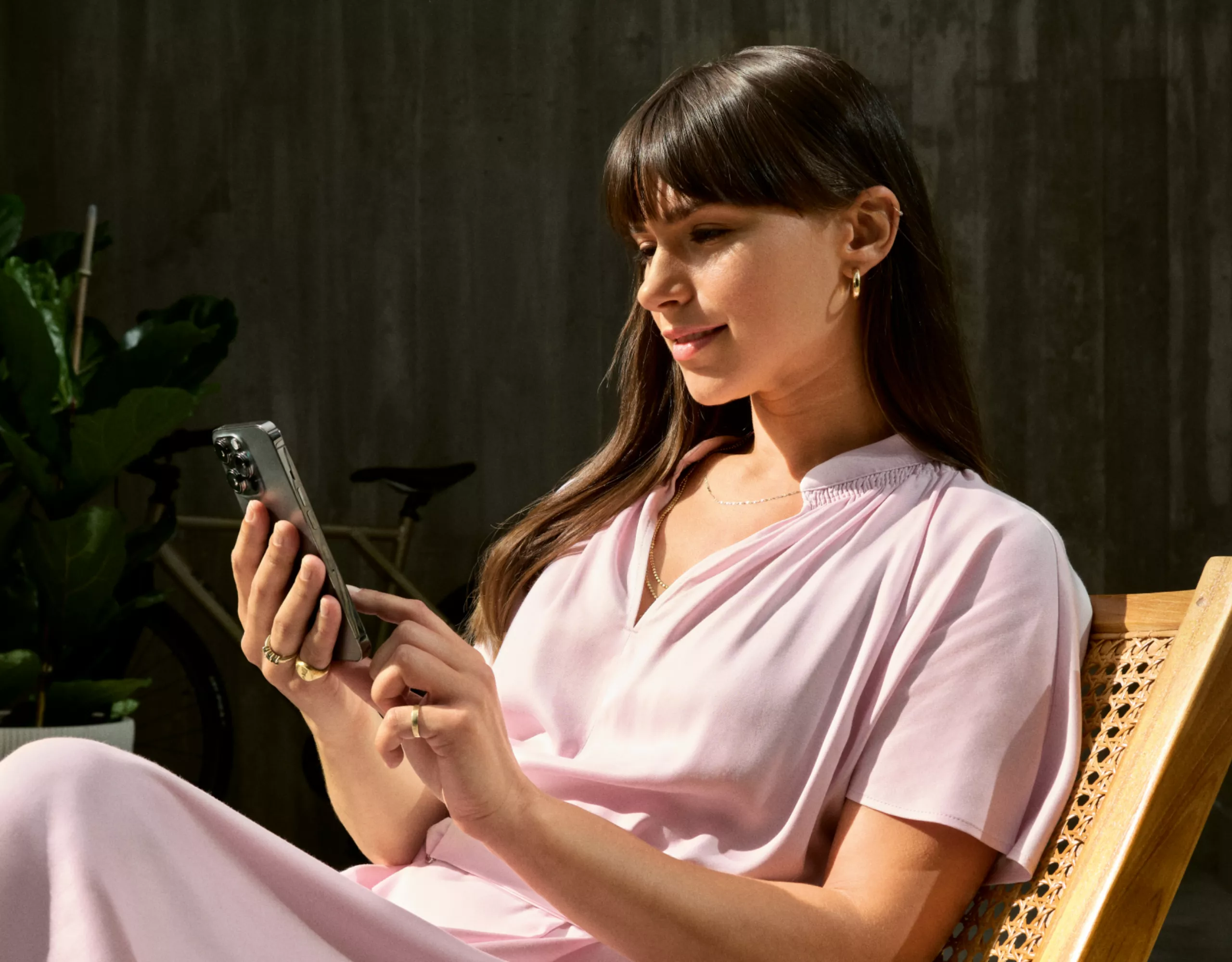 Eine Person mit Smartphone in der Hand sitzt auf einem Stuhl