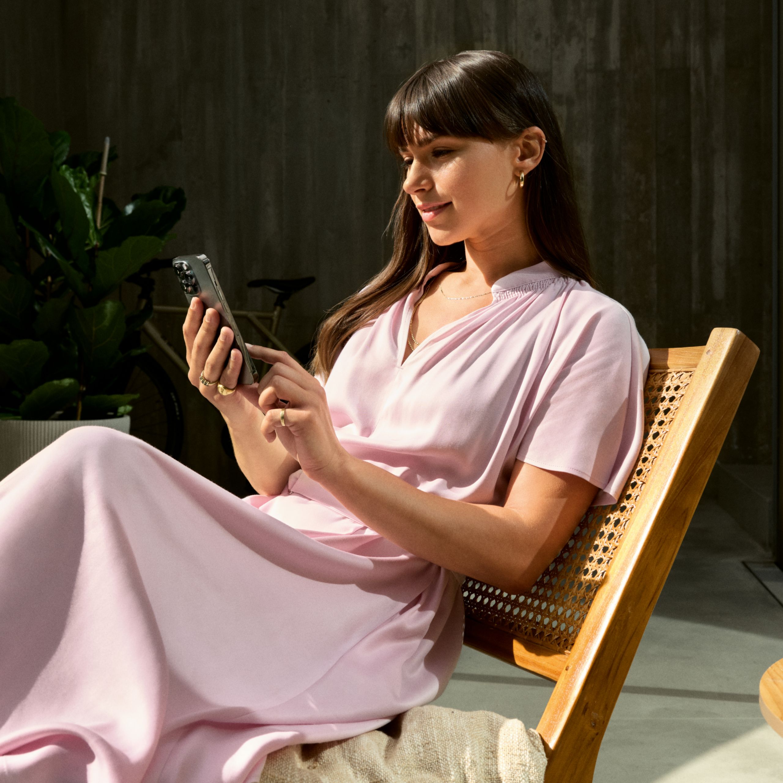 Inimene, kellel on nutitelefon käes, istub toolil