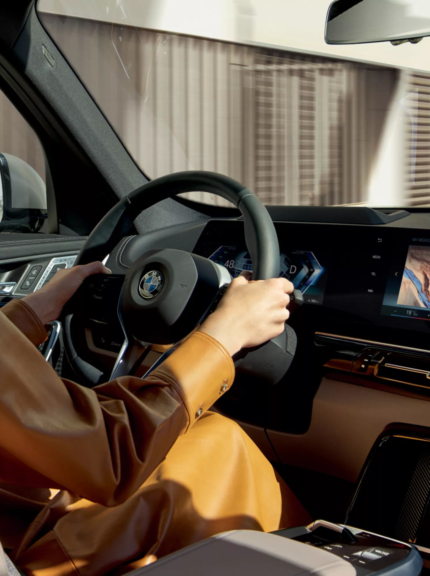 A woman driving in a BMW with Operating System 8