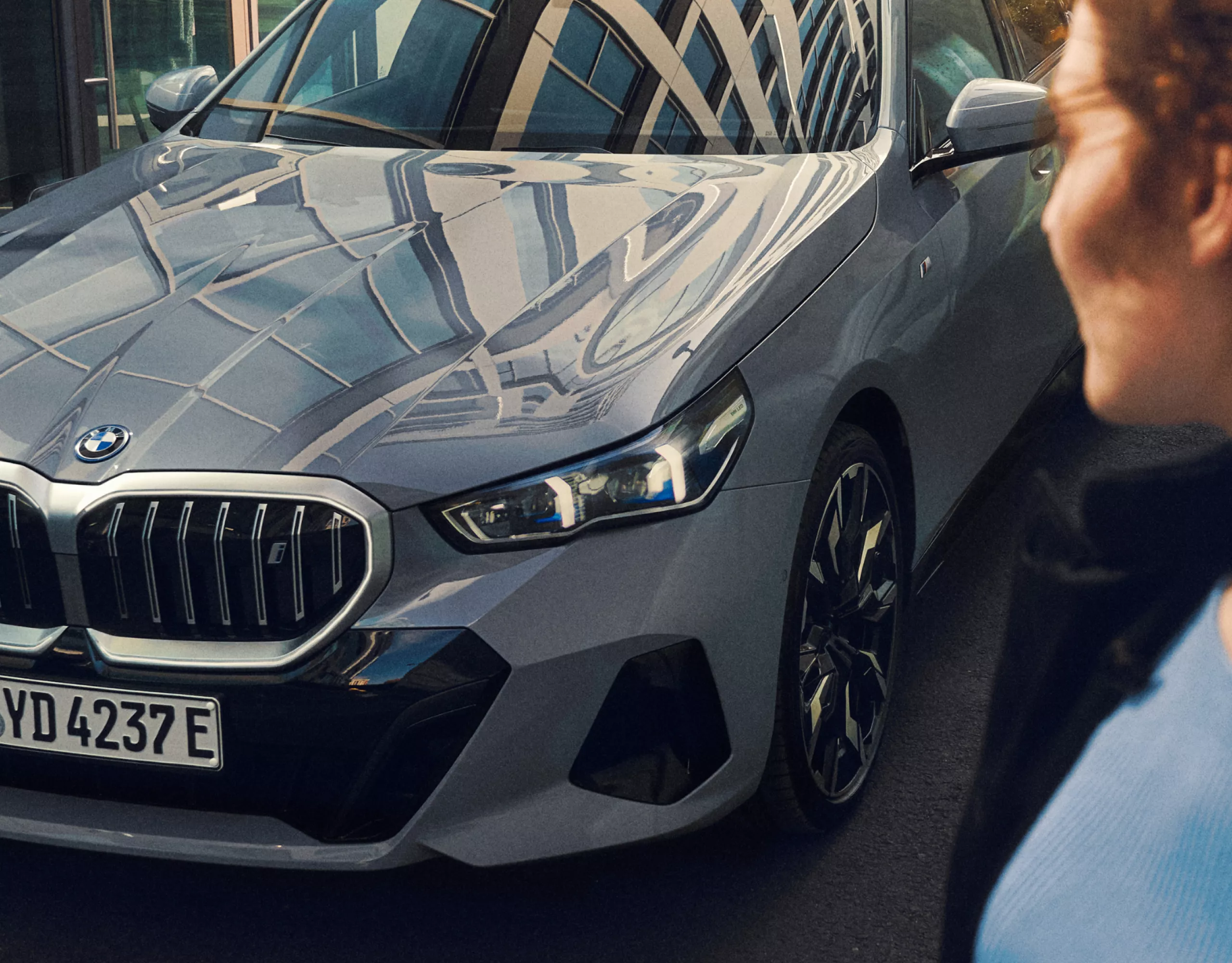 A woman looks at her BMW i5 sedan