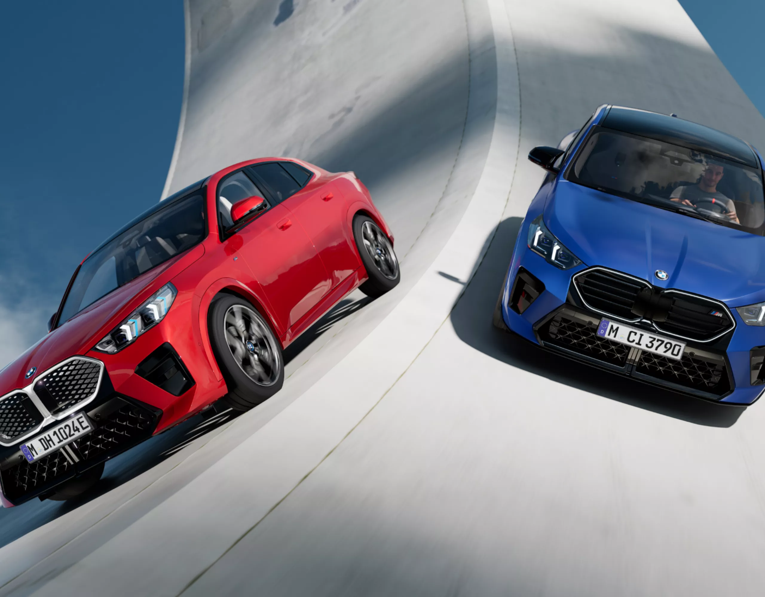 シュールな道路を走る赤と青に塗られた2台のBMW電気自動車