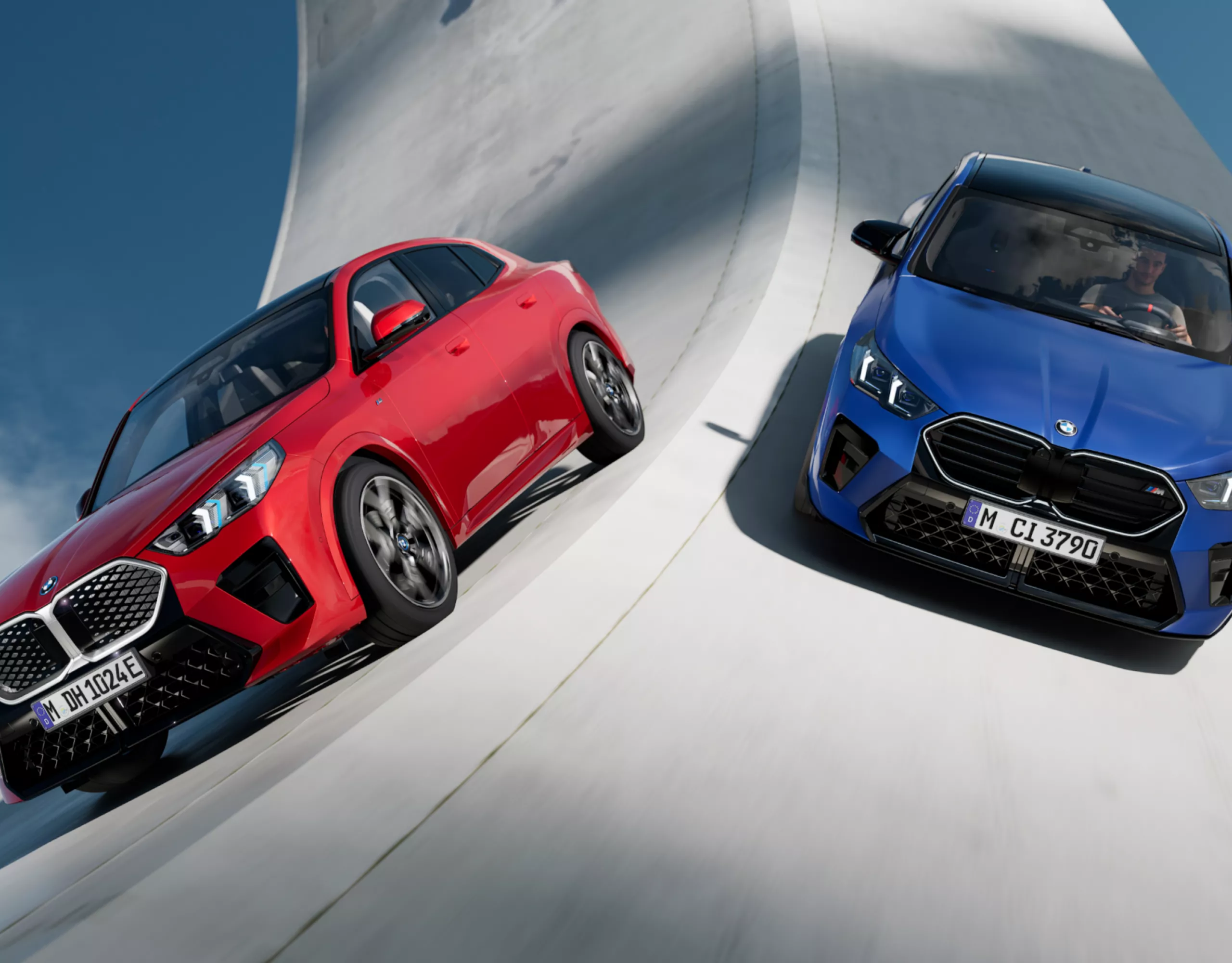 Two BMW electric cars painted red and blue on a surreal road