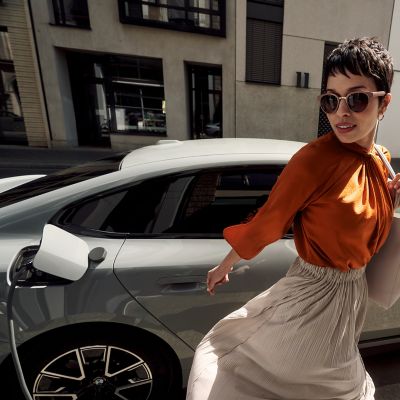 Une personne s’éloigne d’une BMW en cours de recharge