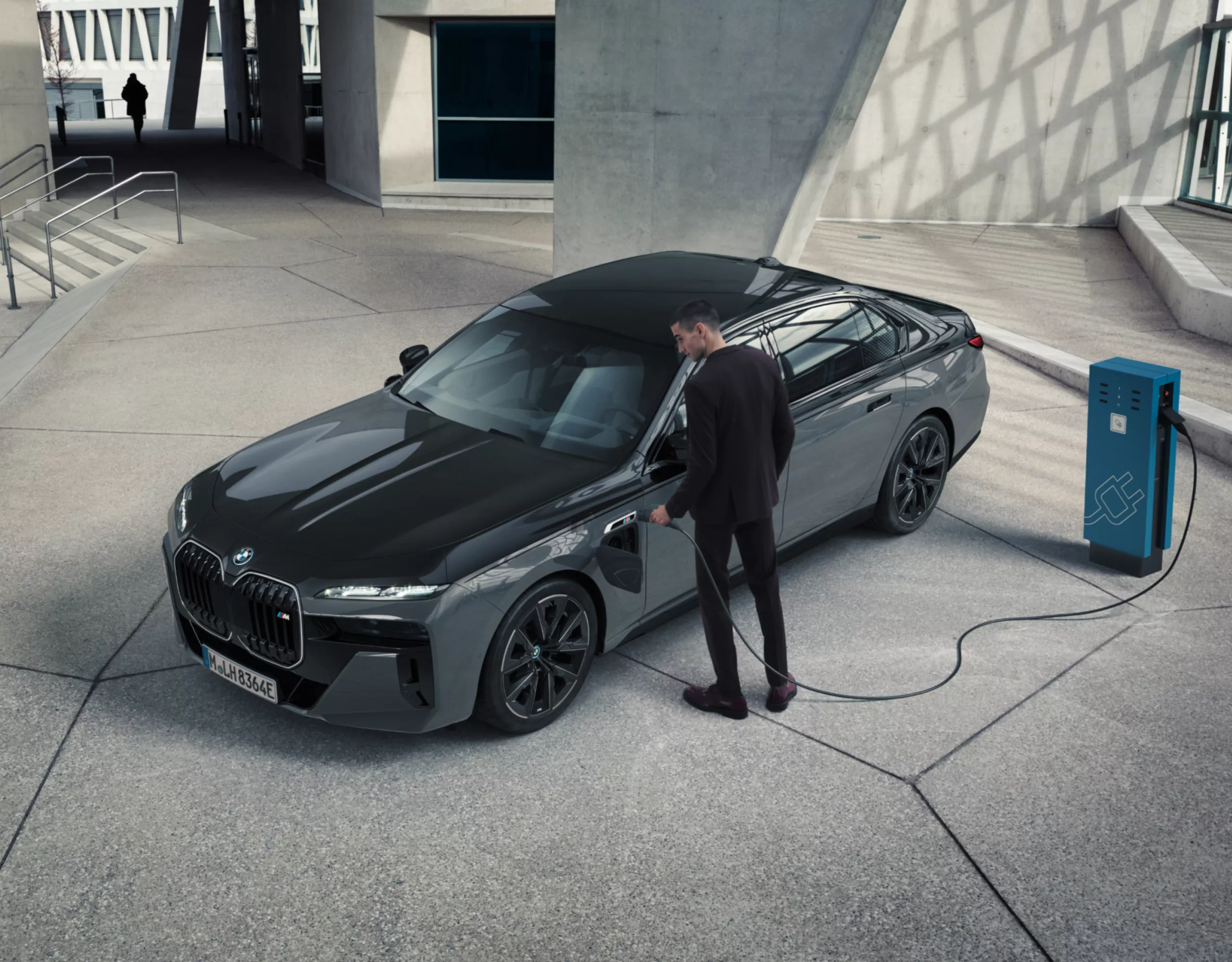 Ein Schwarzer BMW lädt inmitten eines hellen Raums aus Beton und Glas