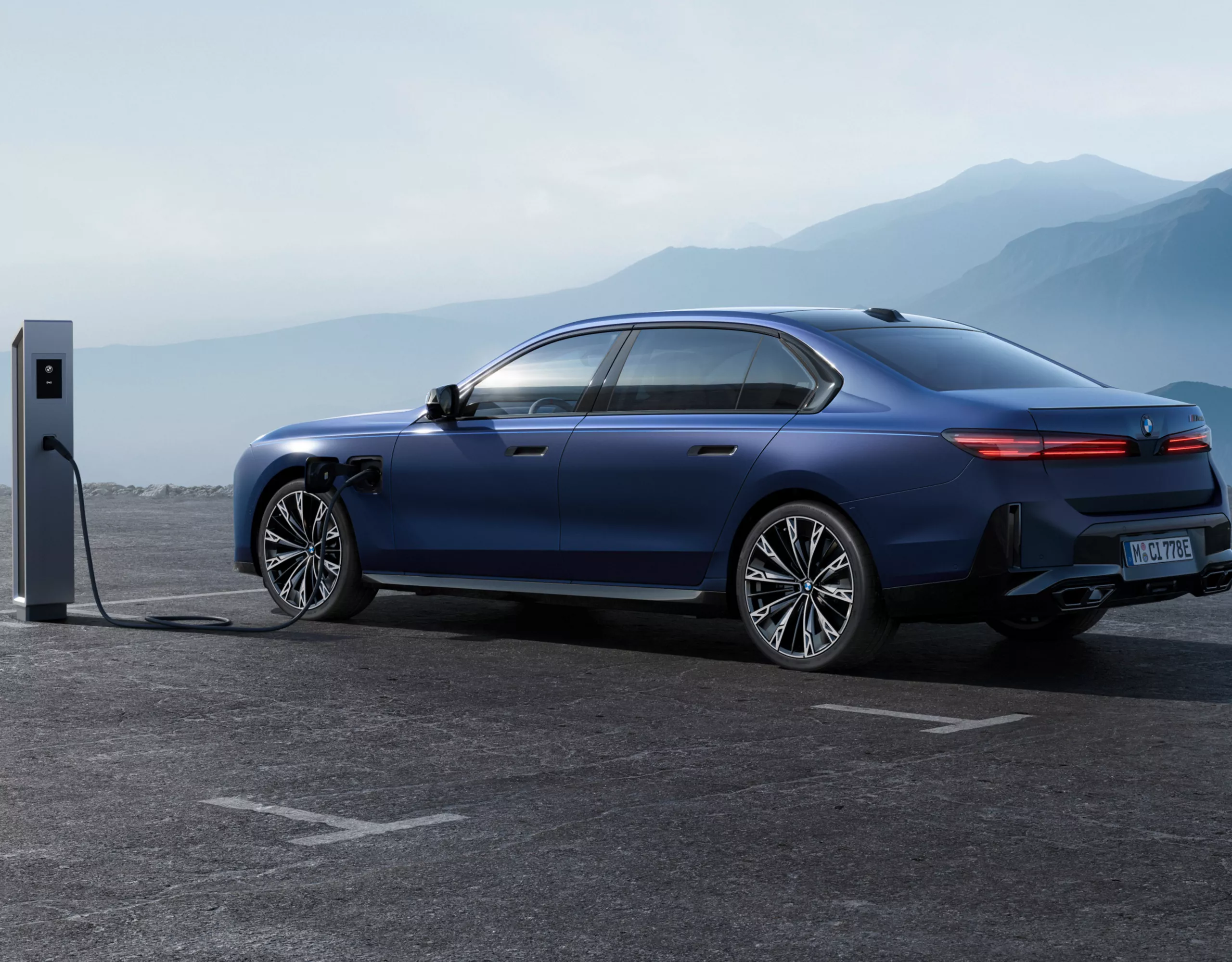 A black BMW charges in a bright concrete and glass room