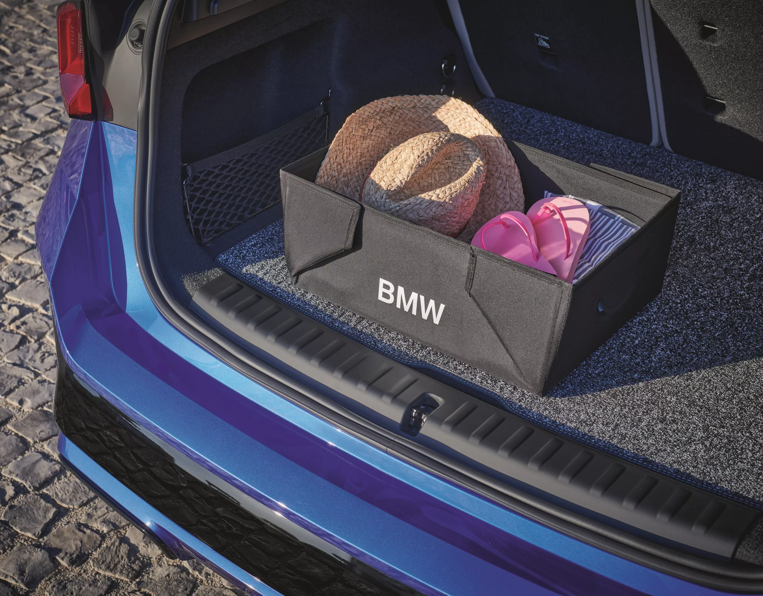 Offener Kofferraum eines blauen BMW mit einer schwarzen BMW Faltbox