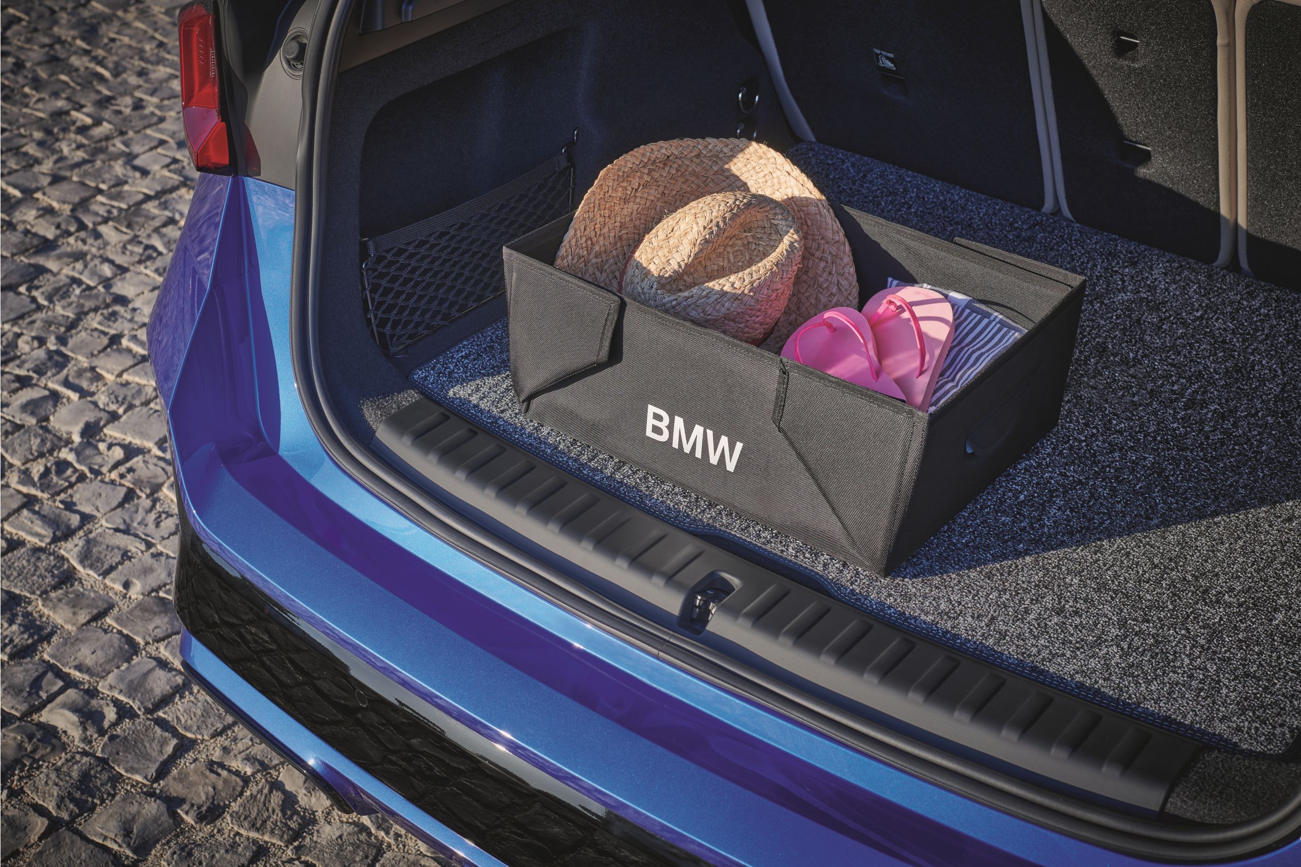 Offener Kofferraum eines blauen BMW mit einer schwarzen BMW Faltbox