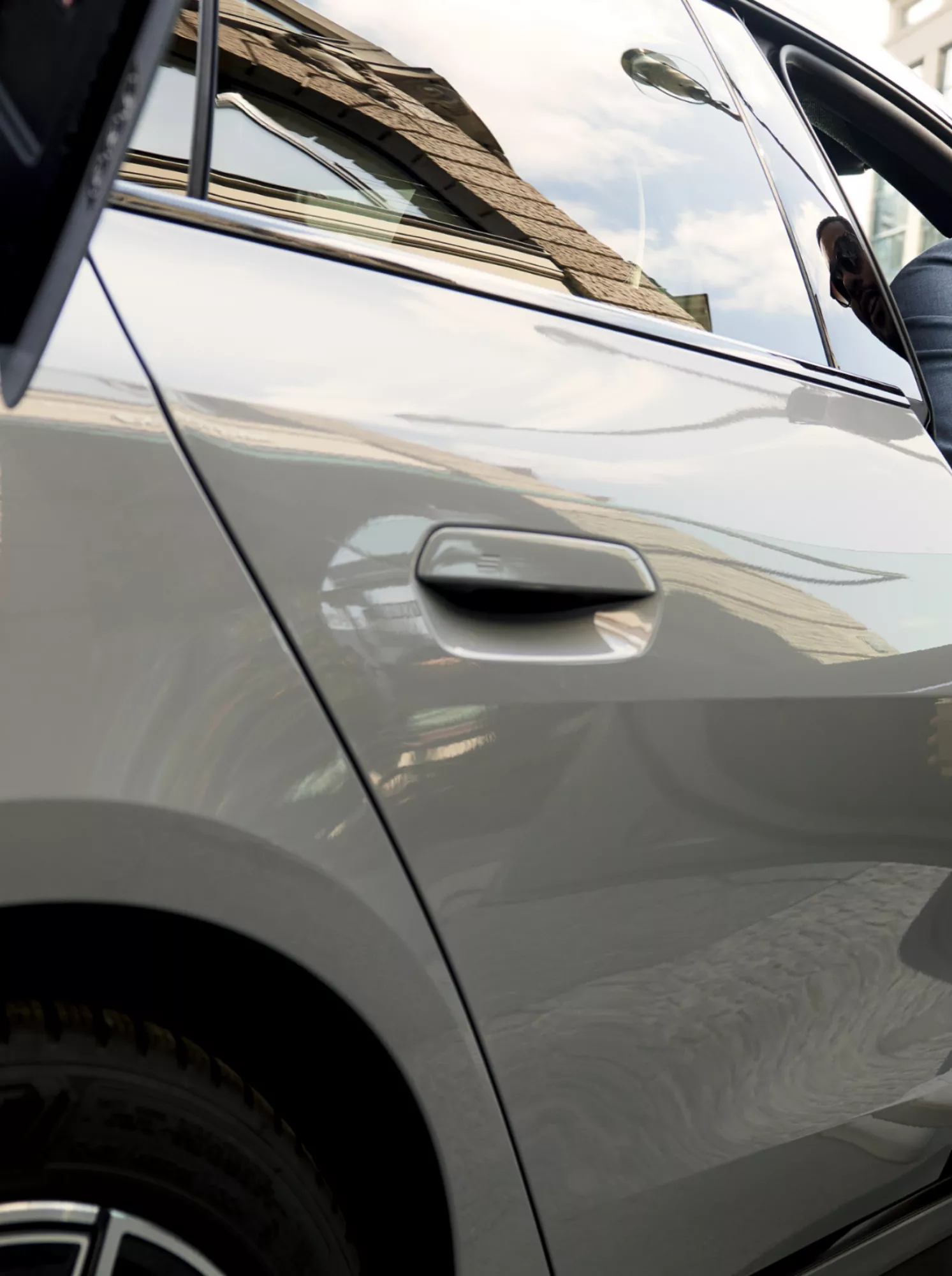 Während der BMW lädt, sitzt ein Mann in der geöffneten Fahrzeugtür