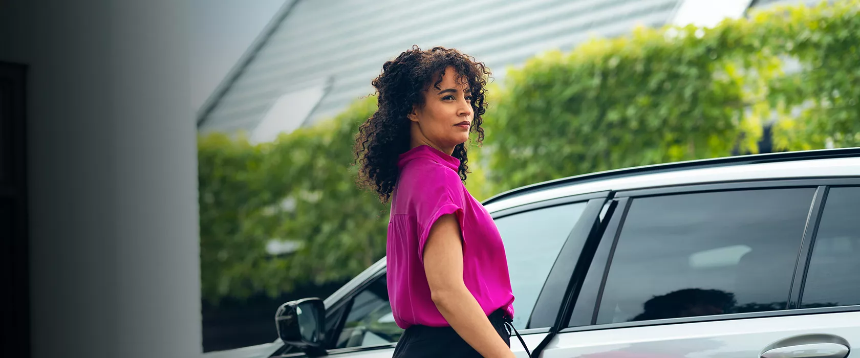 Eine Frau macht die Türe eines Fahrzeugs auf