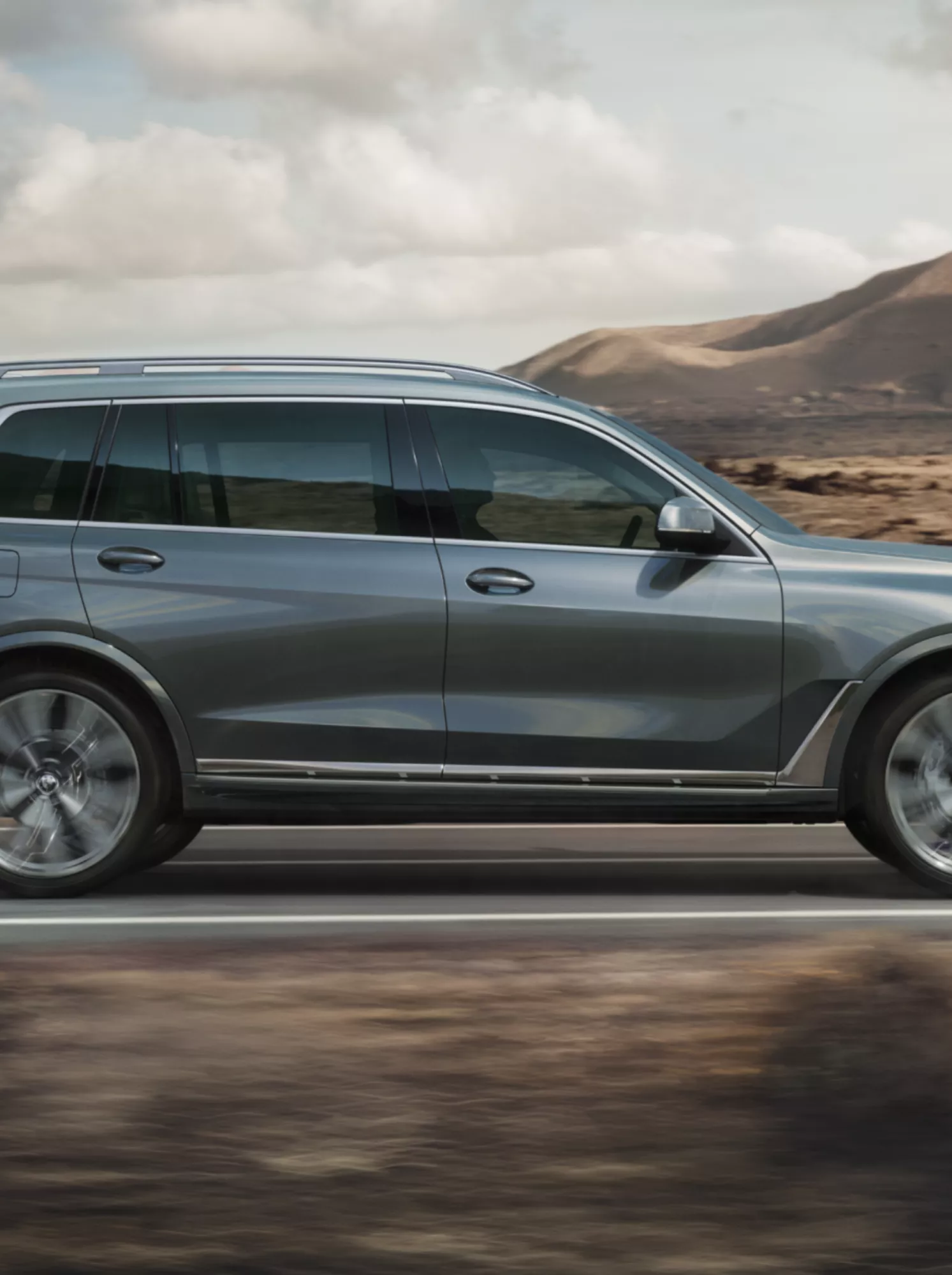 Een BMW X7 rijdt met hoge snelheid door een hamada-woestijnlandschap