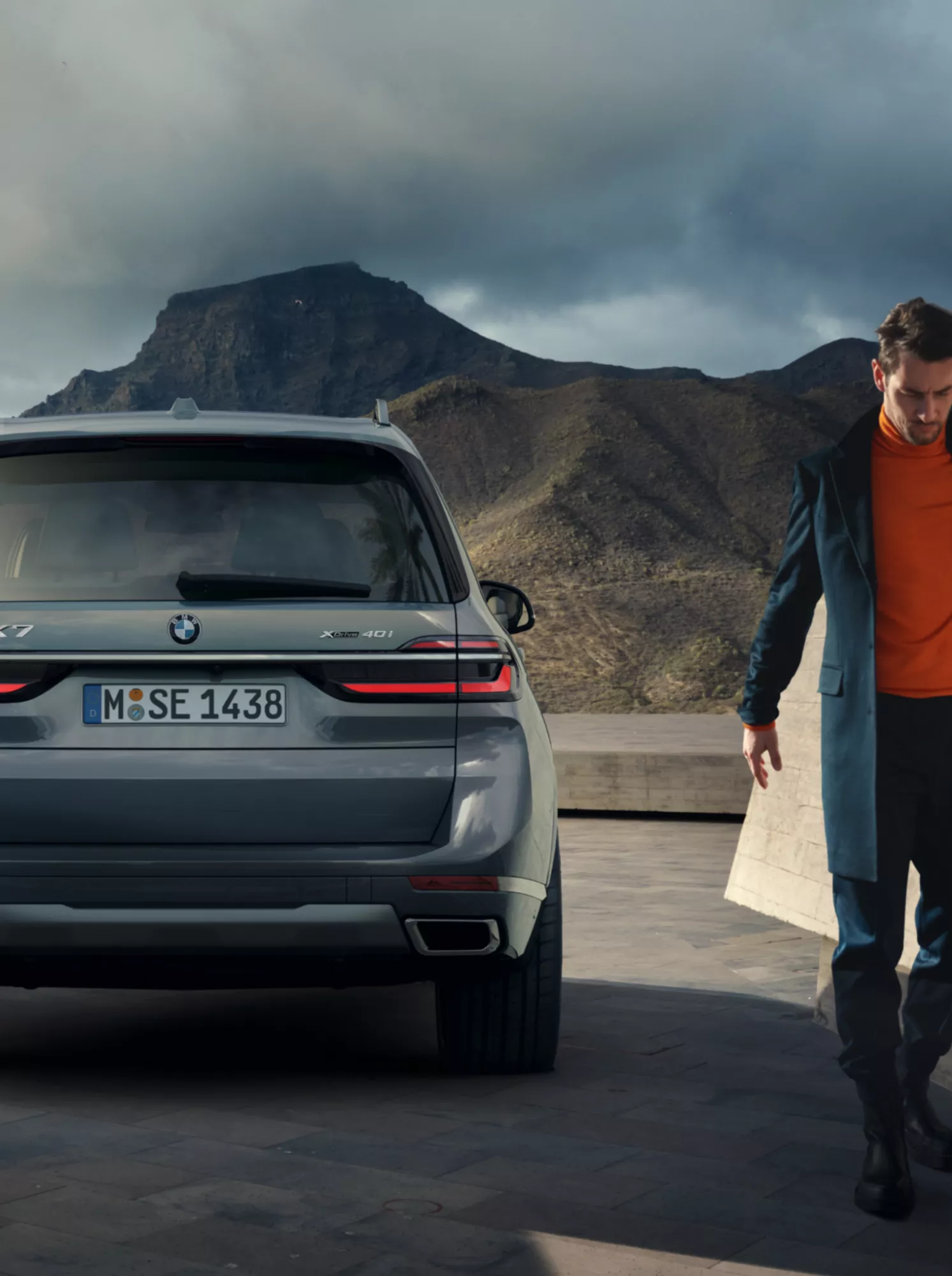 Ein gut gekleideter Mann entfernt sich von seinem BMW X7