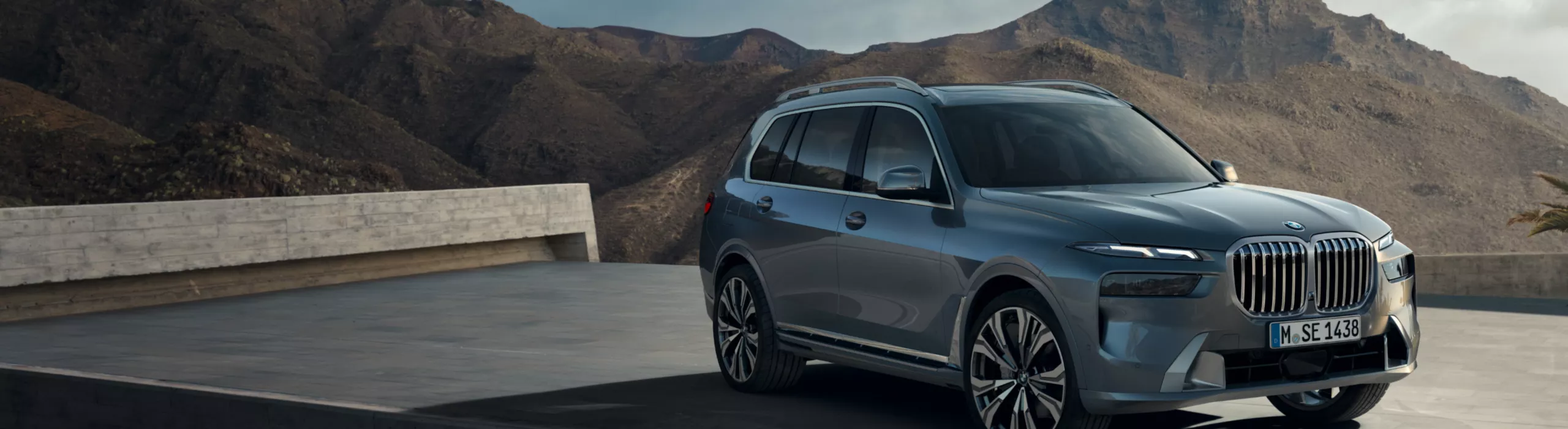 Ein BMW X7 ist auf einer Plattform vor einem Felsengebirge geparkt