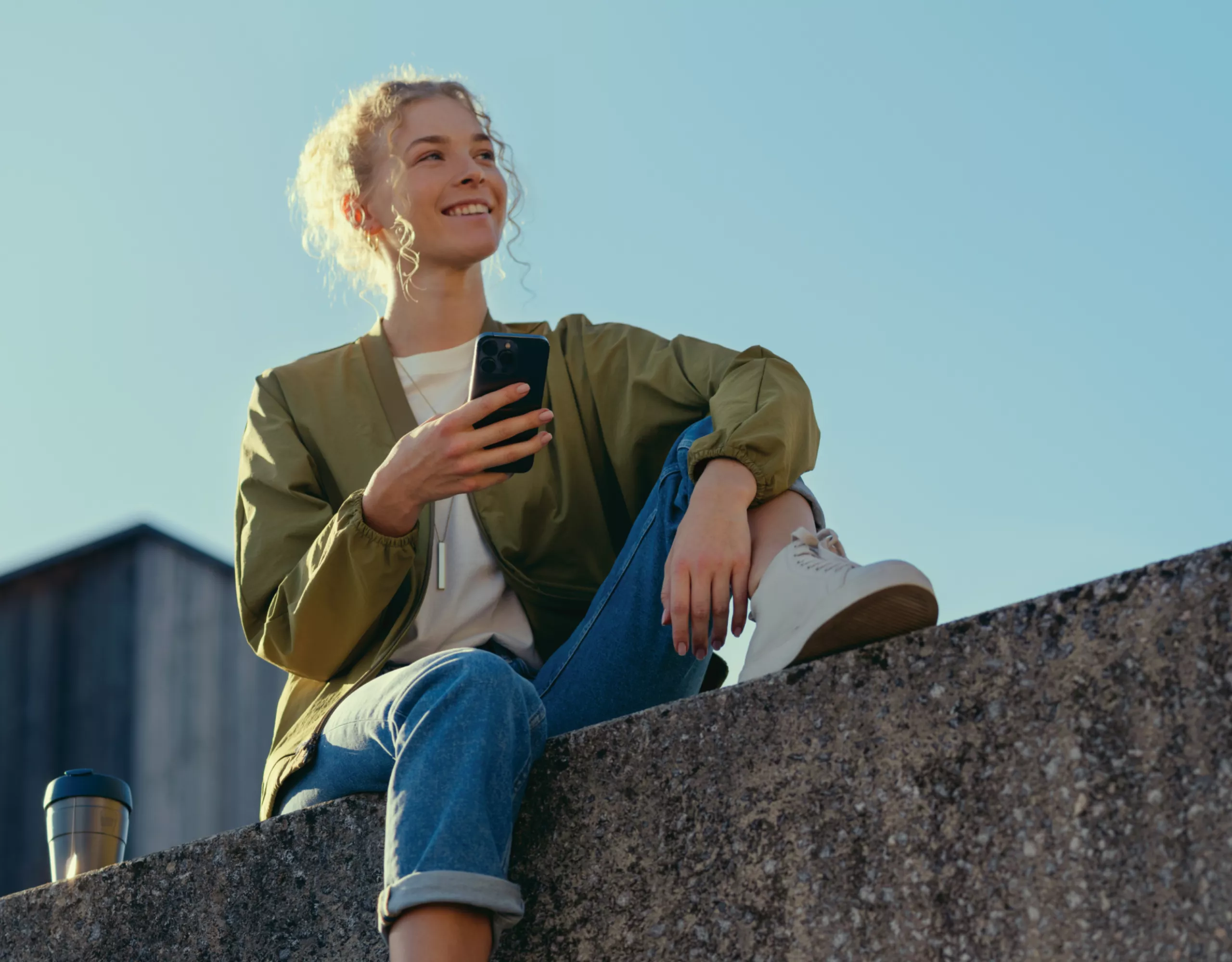 BMW 3シリーズ セダン：スマートフォンでMy BMWアプリを利用する女性