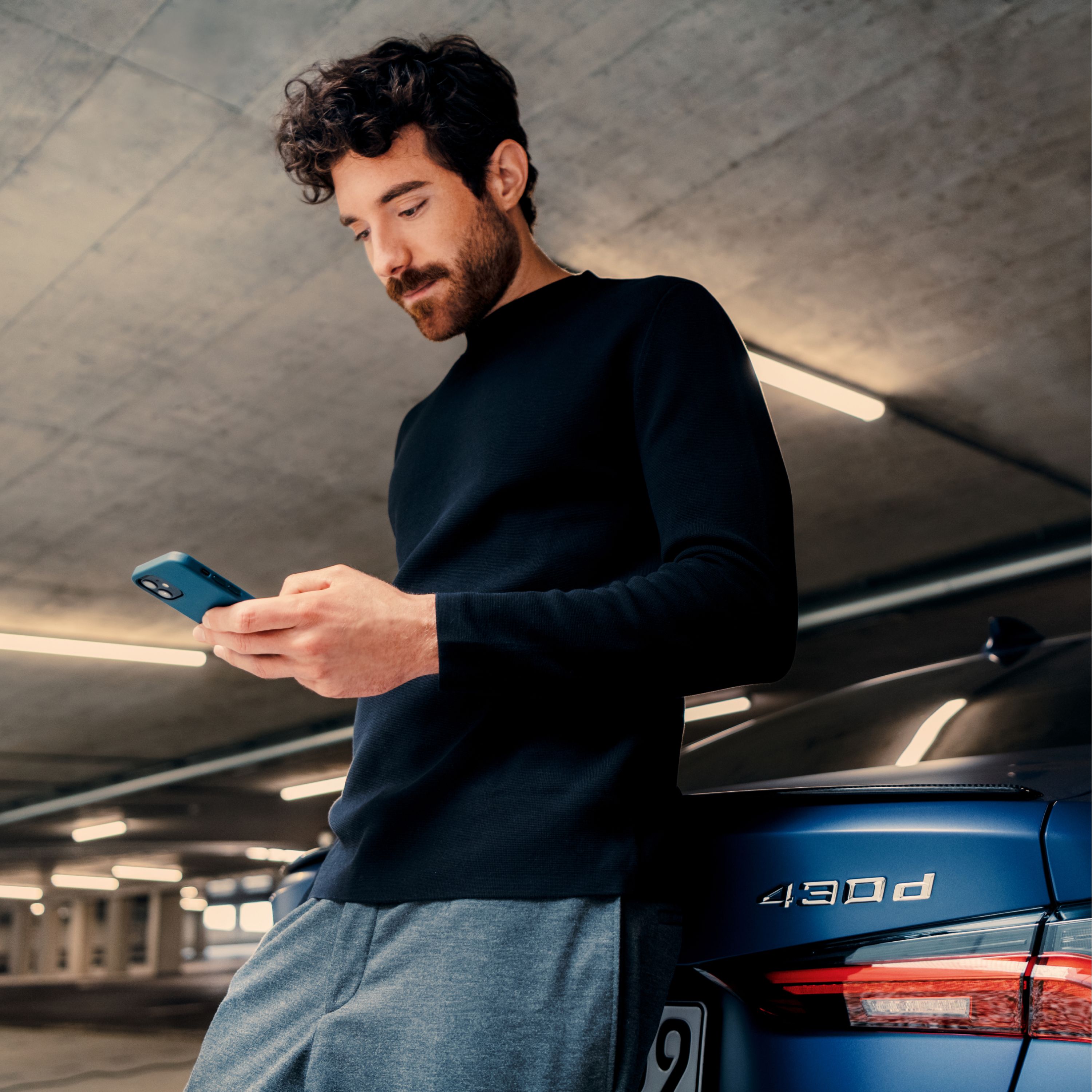 BMW i4 M50 xDrive：スマートフォンでMy BMWアプリを利用する男性