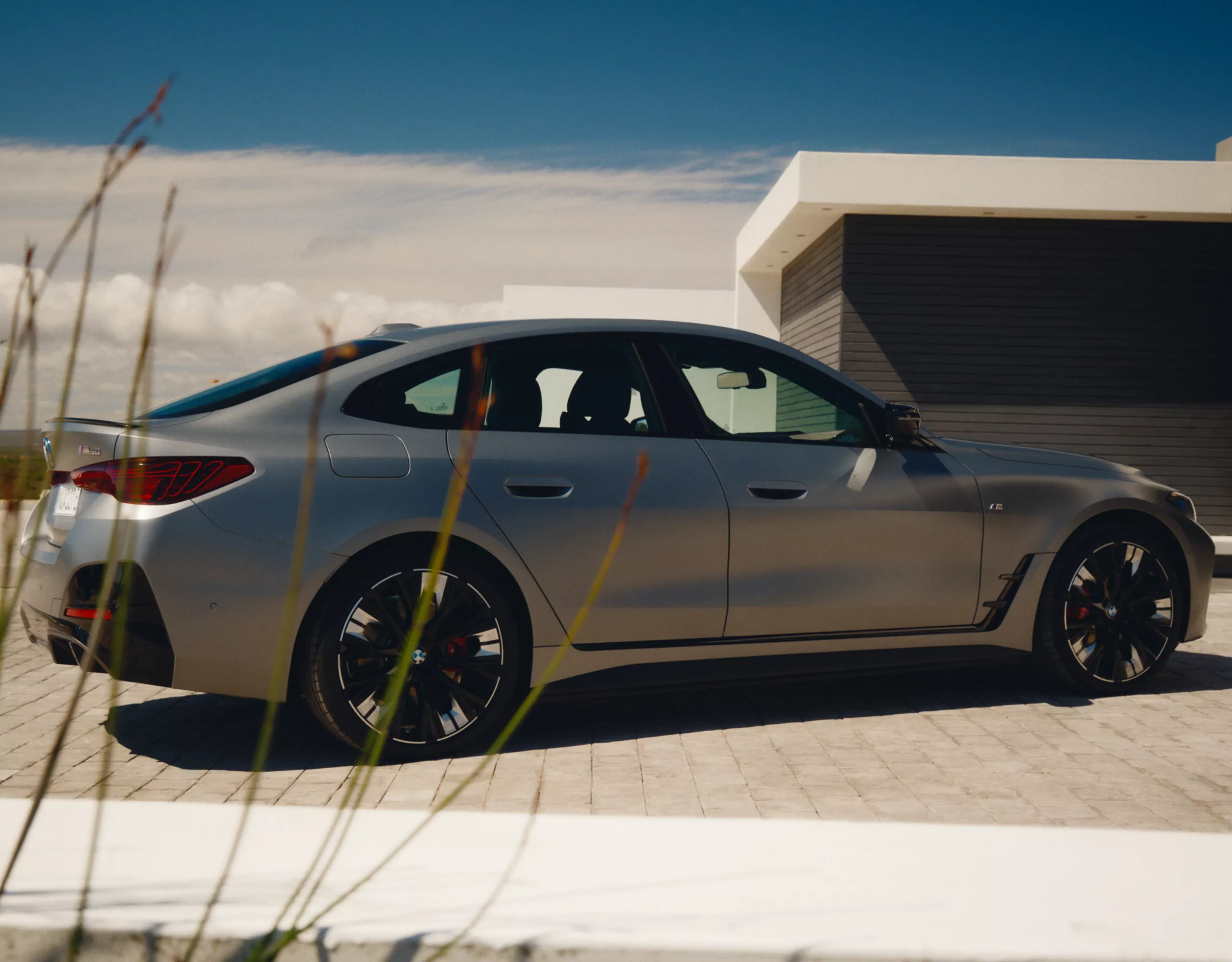 BMW i4，純電轎跑，Mineral White Metallic銀粉漆，在穿越沙漠的寬闊道路上高速行駛