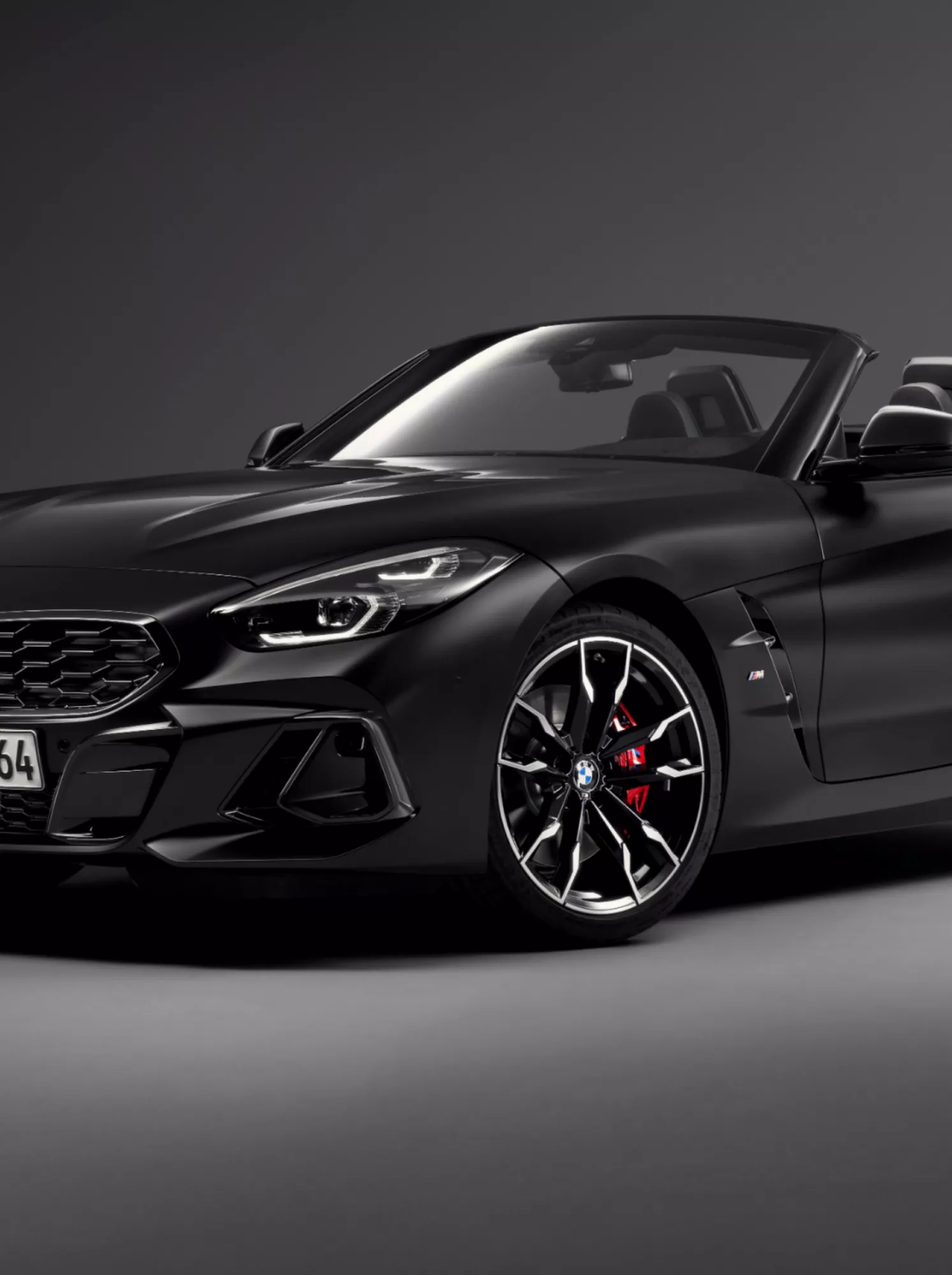 Frontalansicht des BMW Z4 M40i Roadster Final Edition in BMW Individual Frozen Black metallic mit offenem Verdeck und roten BMW M Sportbremse