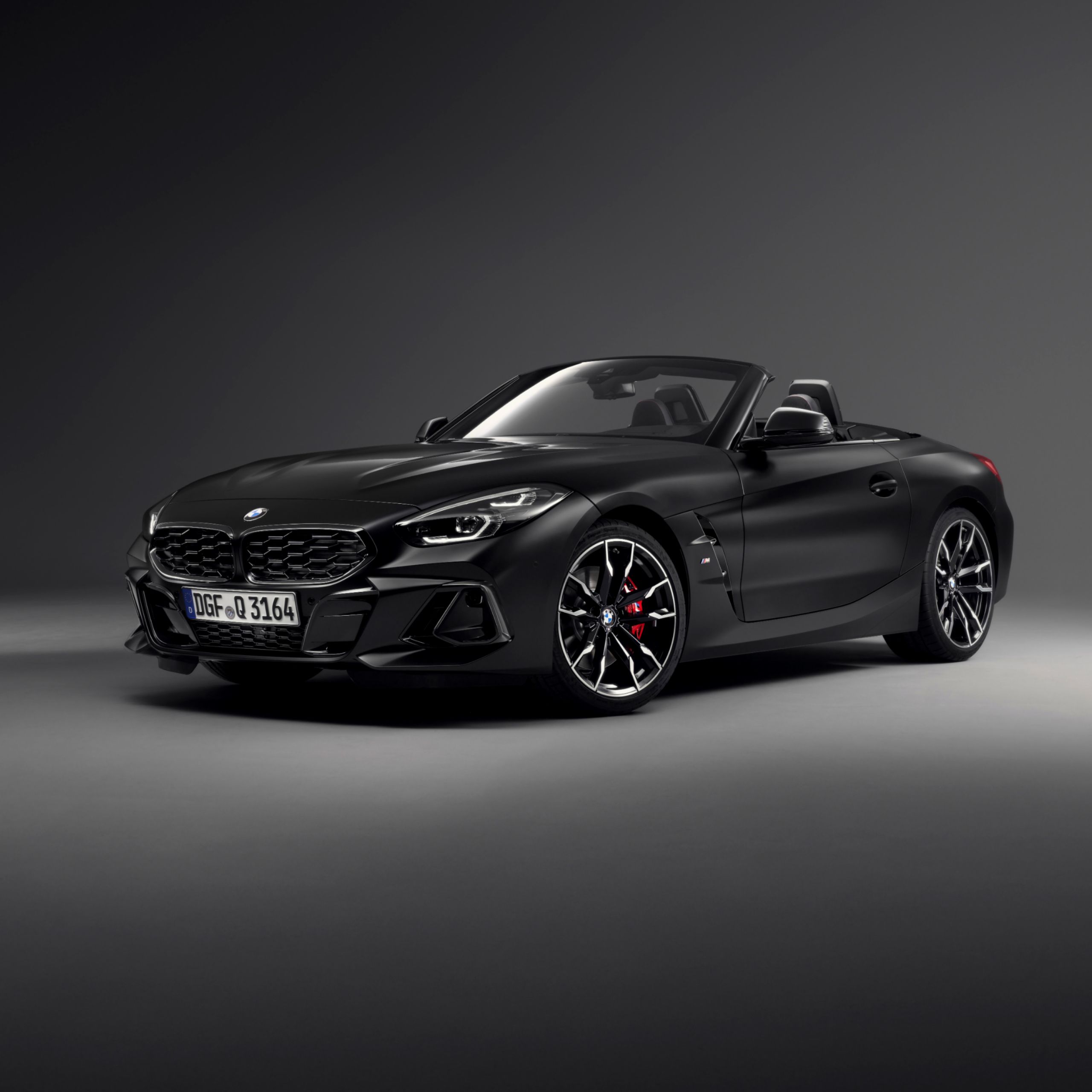 Vue de face de la BMW Z4 M40i Roadster Final Edition déclinée en BMW Individual Frozen Black métallisé, avec toit ouvert et frein sport BMW M rouge
