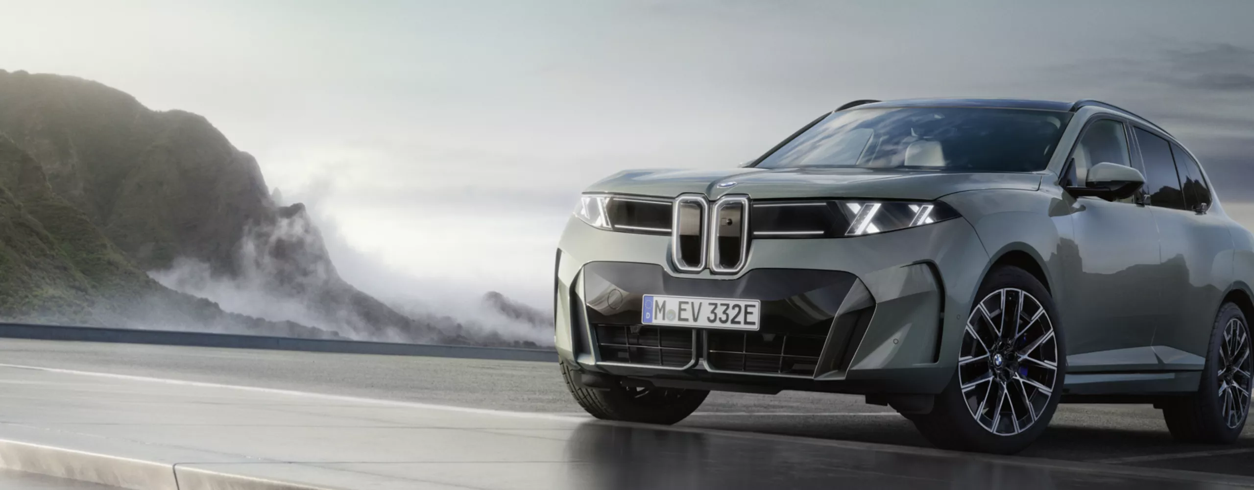 一輛BMW iX5從右側駛入畫面，背景為白色。