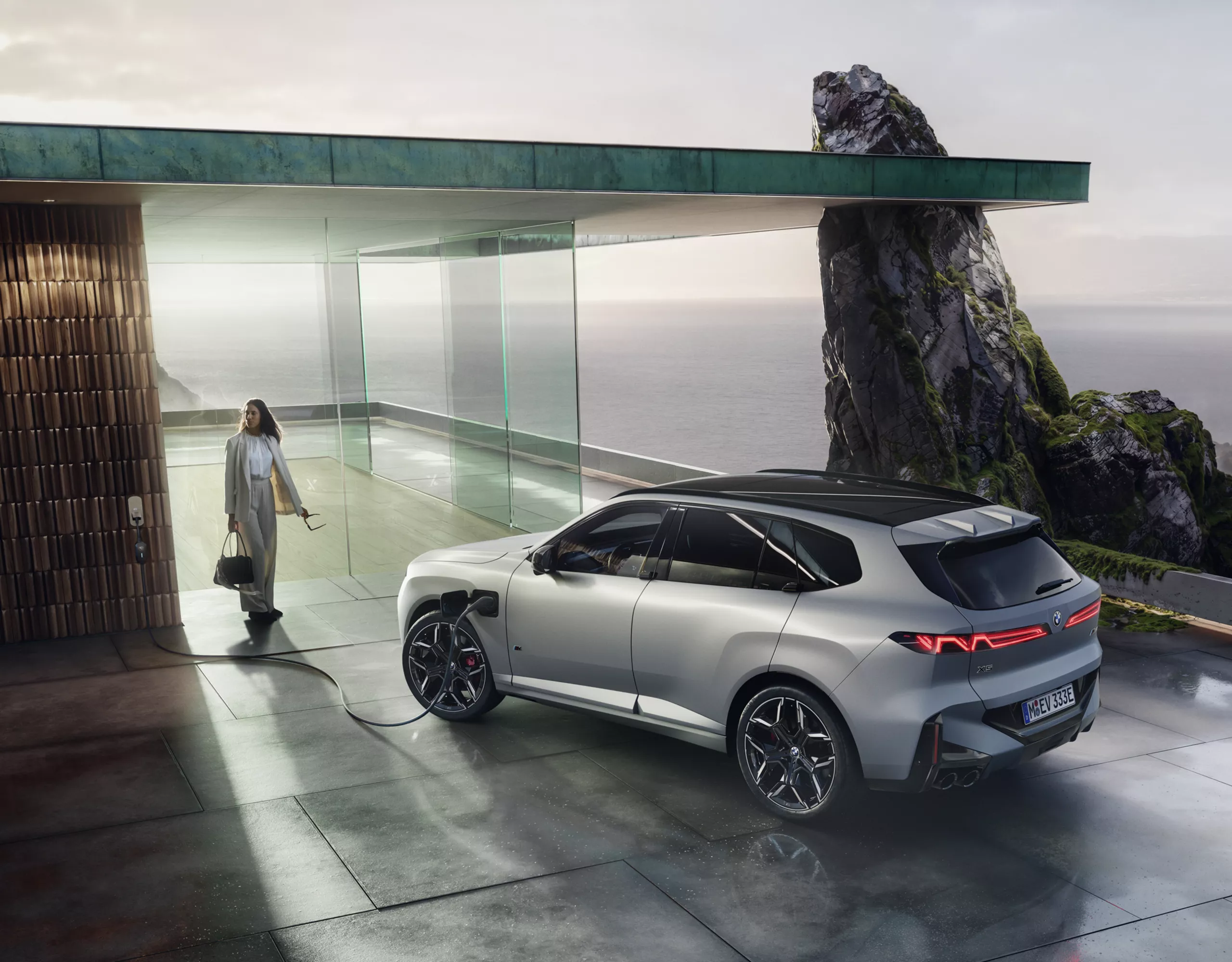 BMW seisab moodsal terrassil, millelt avaneb vaade ookeanile, ja sõiduki kõrval asub kalju.