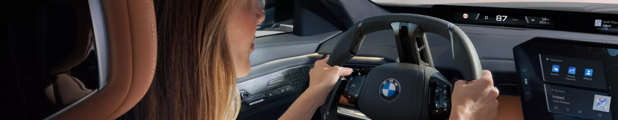 View from the rear seat bench to the driver, the steering wheel and the central information display.