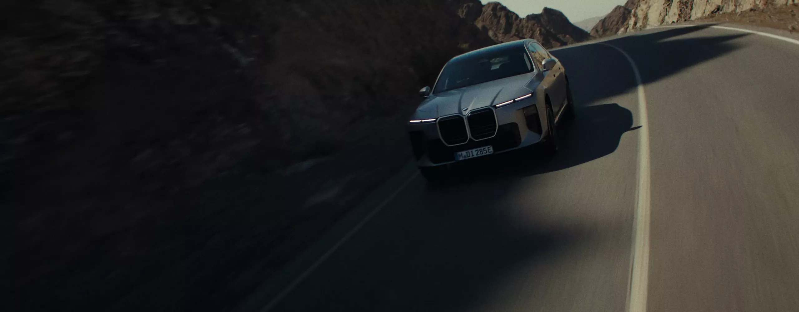 A dynamic driving video showcases the vehicle from all angles as it navigates winding roads through a scenic landscape, driven by a male model.