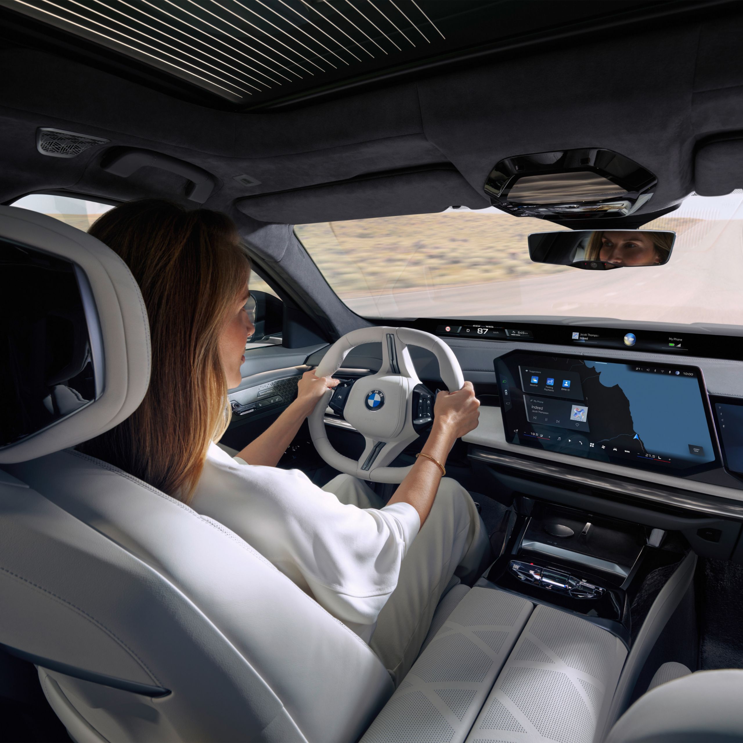 View from the rear seat bench to the driver, the steering wheel and the central information display.