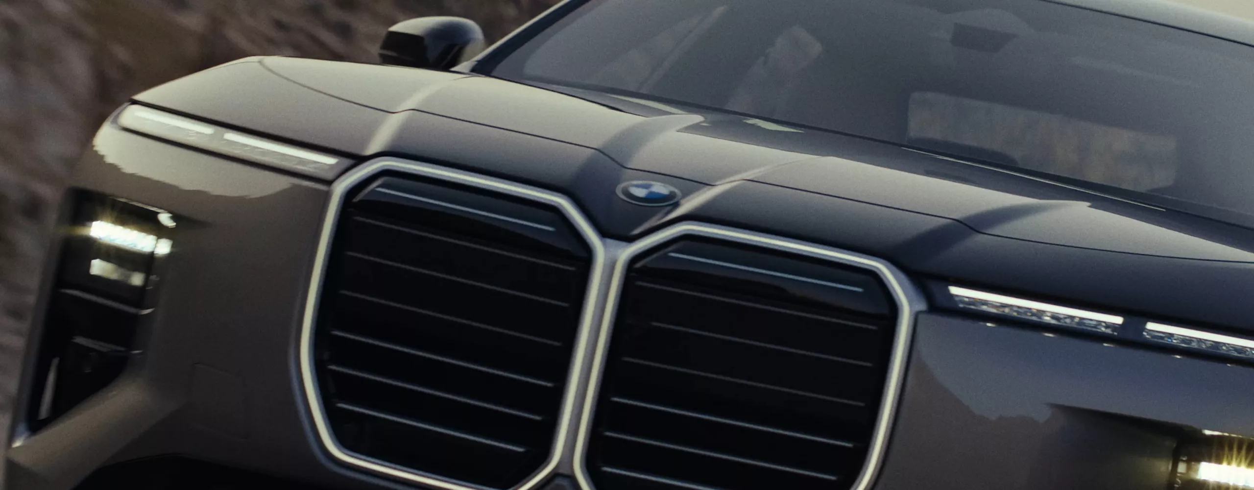 A dynamic driving video showcases the vehicle from all angles as it navigates winding roads through a scenic landscape, driven by a male model.