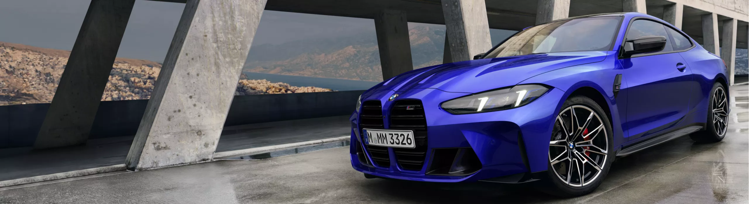 BMW M4 Competition Coupé Exterieuransicht auf einer nassen Betonbrücke über eine Wasserstraße