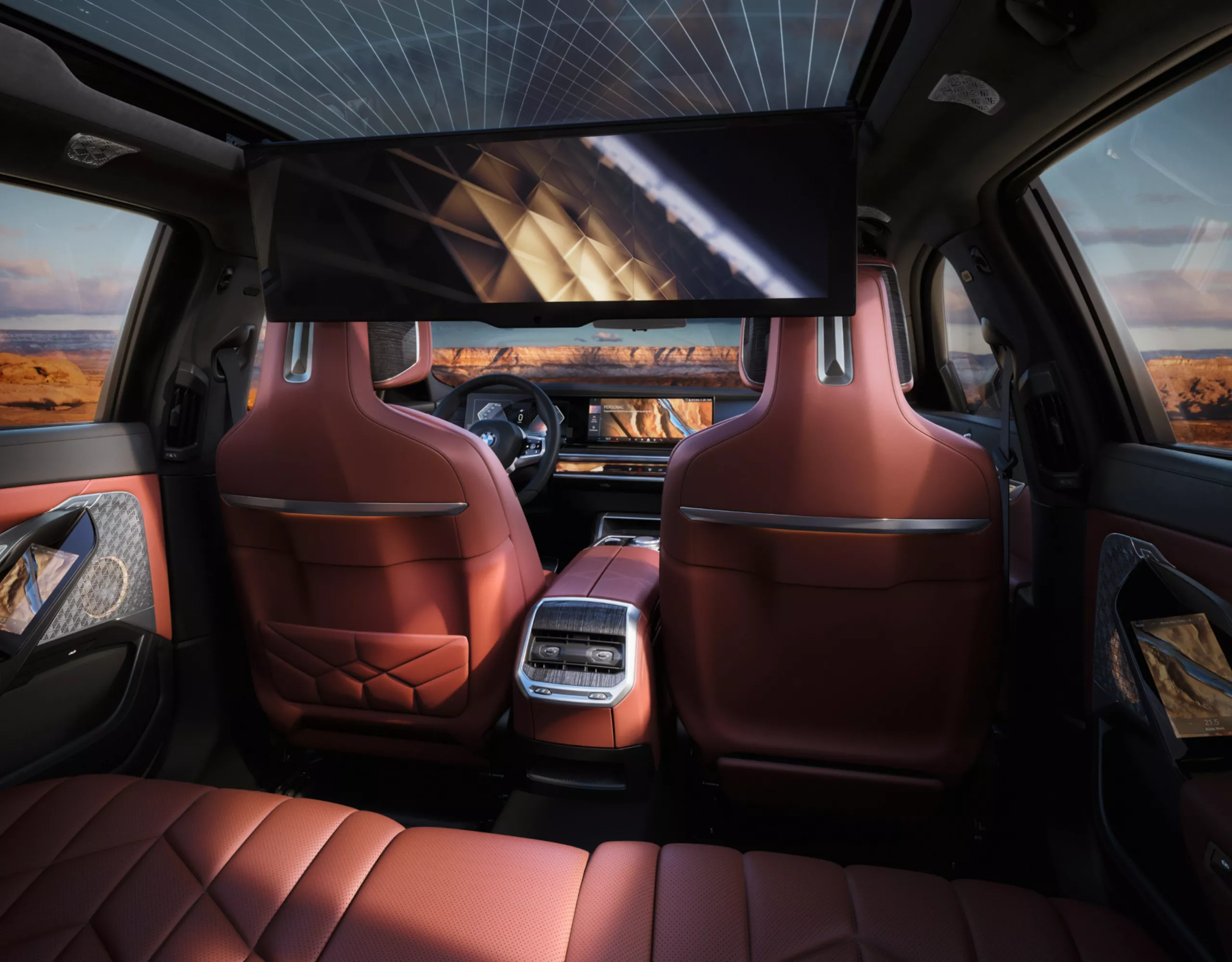 BMW 7 Serisi Sedanın iç tasarımı, gün batımında arka koltuklardan deri koltuklar ve panoramik tavana sahip kabinin görünümü