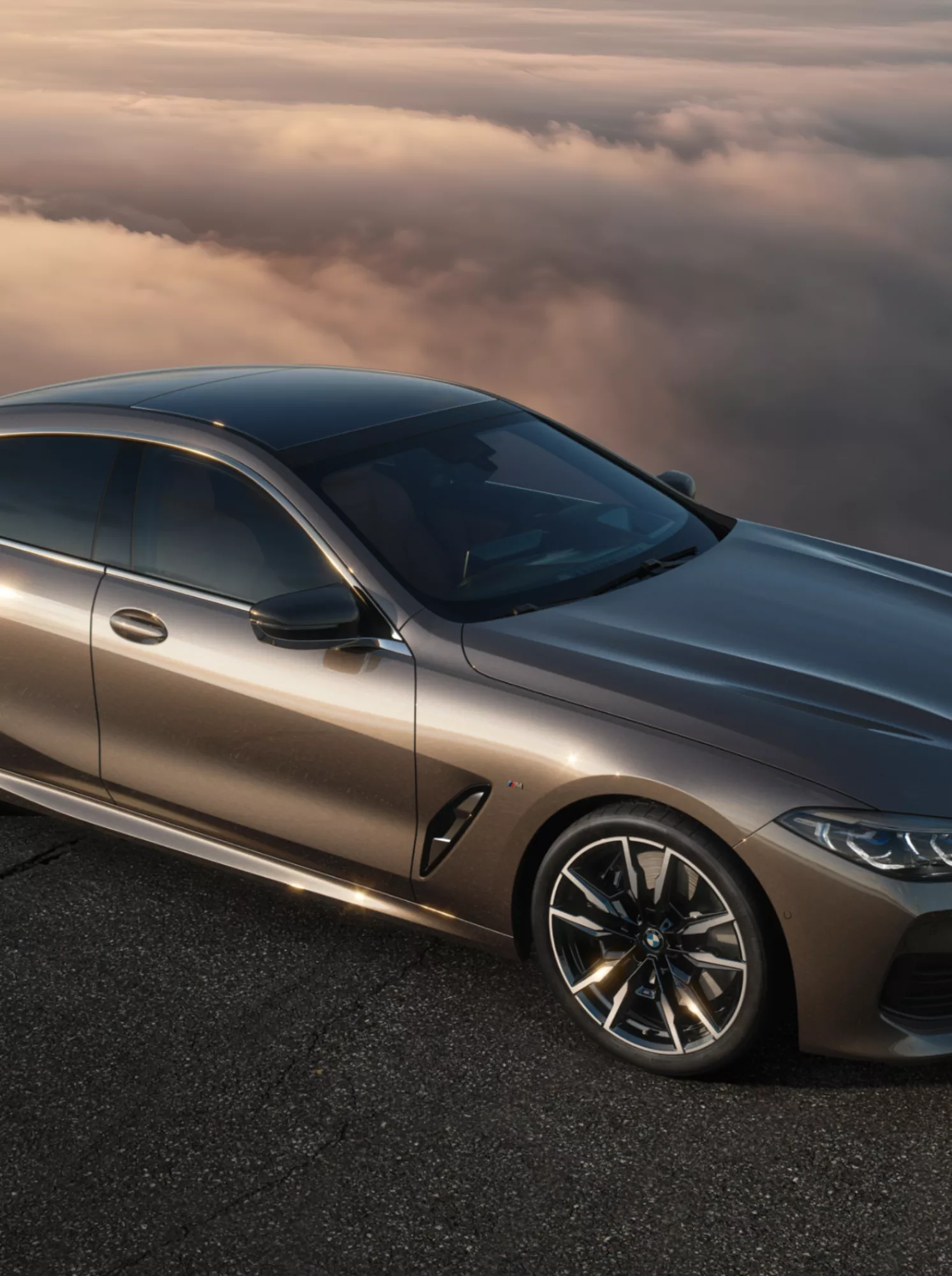 BMW M850i xDrive Gran Coupé on a mountain street, surrounded by clouds