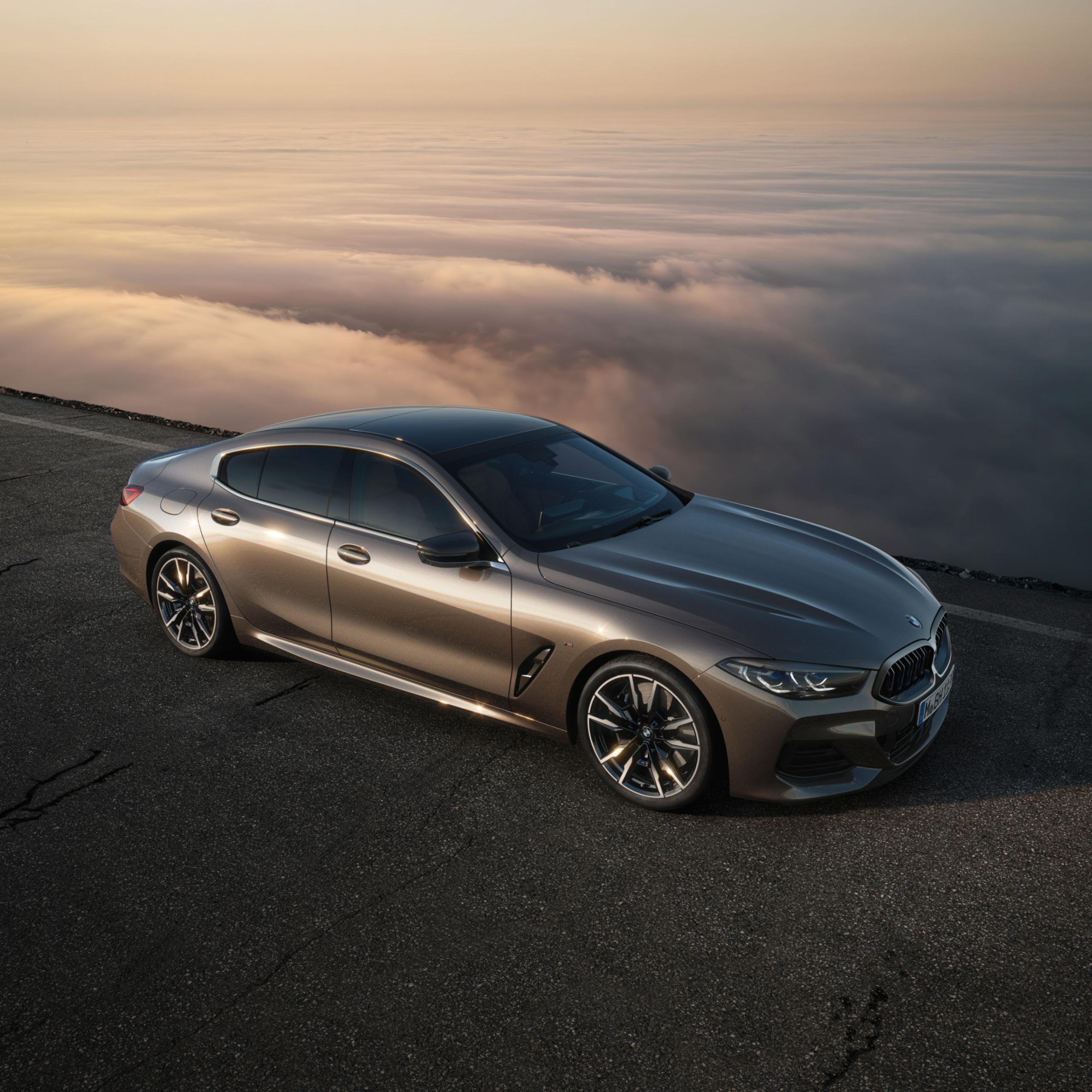 BMW M850i xDrive Gran Coupé auf einer Gebirgsstraße umgeben von Wolken