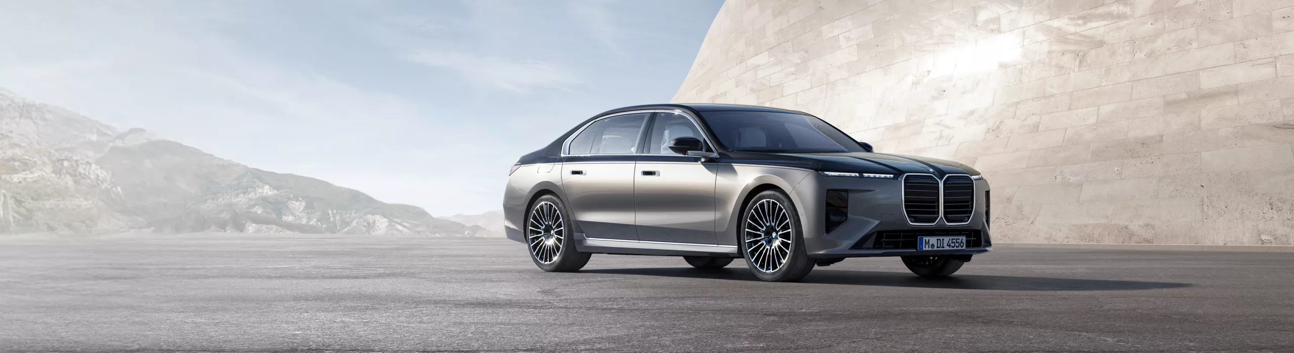 Berlina BMW Série 7 sobre asfalto, em frente a uma parede