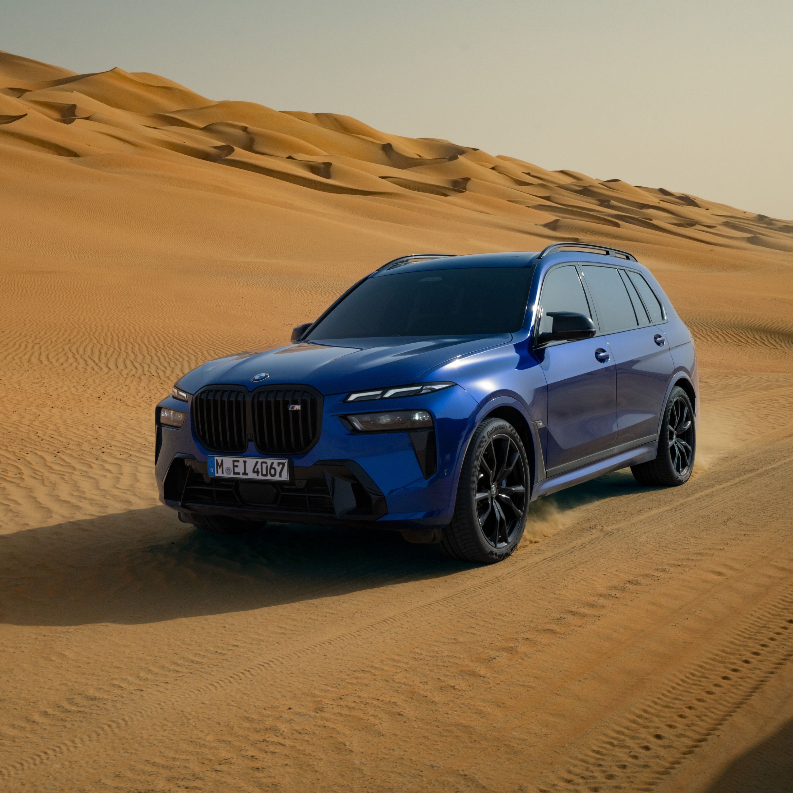BMW X7 M60i xDrive egy parkolóhelyen egy futurisztikus épület előtt