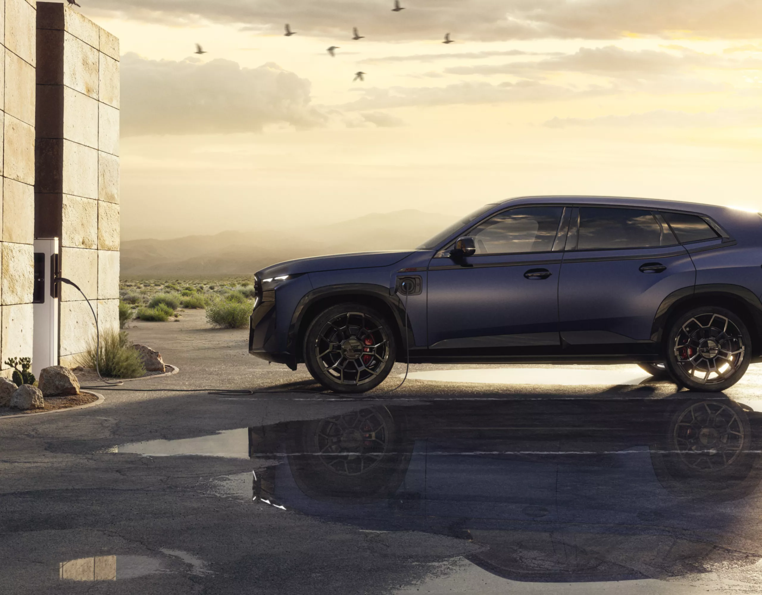 BMW XM Label com cenário de colina e paisagem ao entardecer