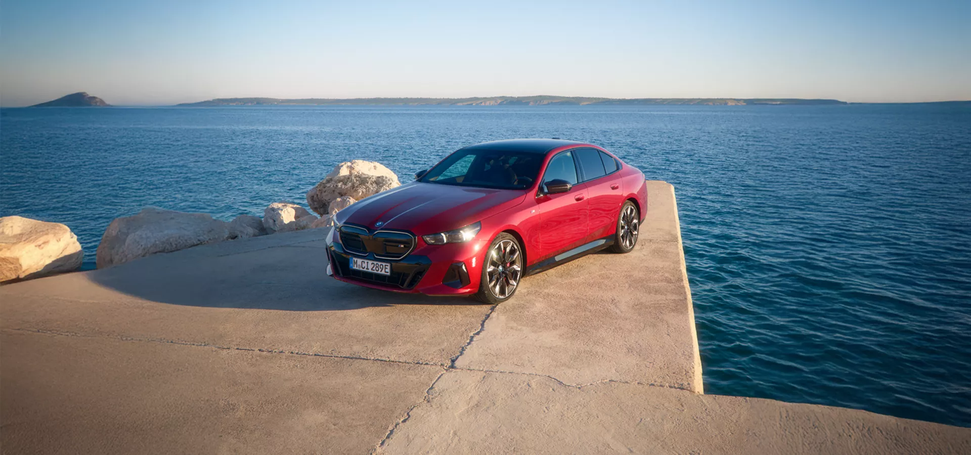 Eine rote, vollelektrische BMW i5 Limousine