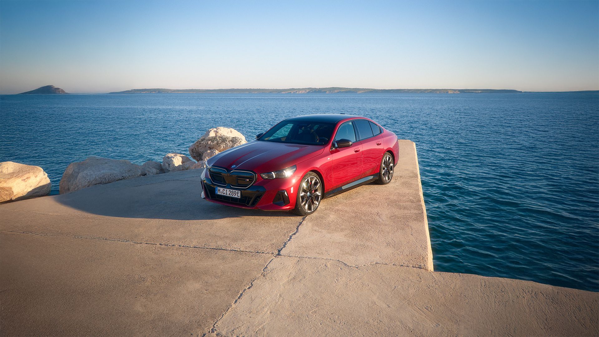 Eine rote, vollelektrische BMW i5 Limousine